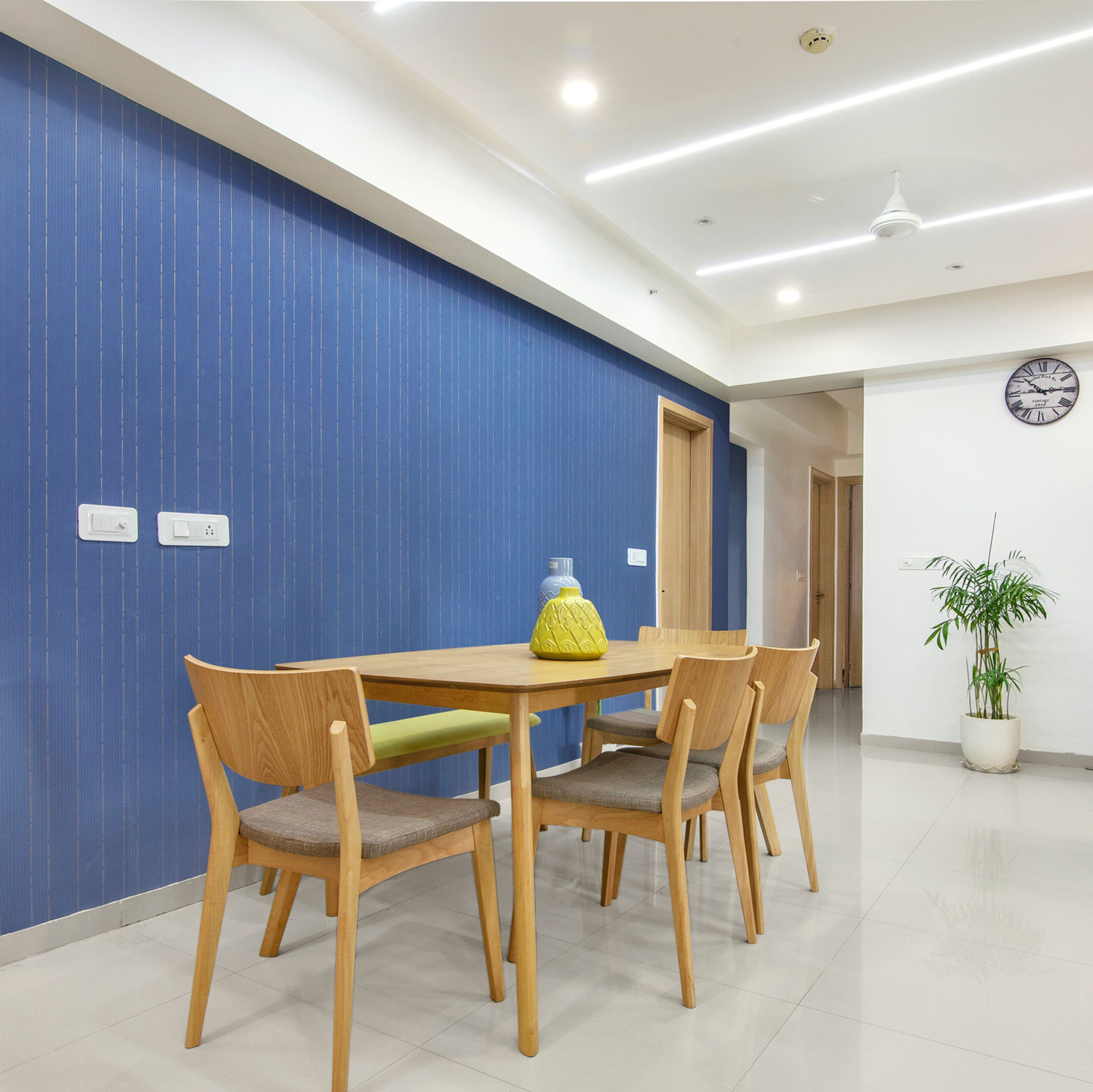 White And Grey 4-Seater Dining Room Table With Green Bench And Blue Accent Wall - Livspace