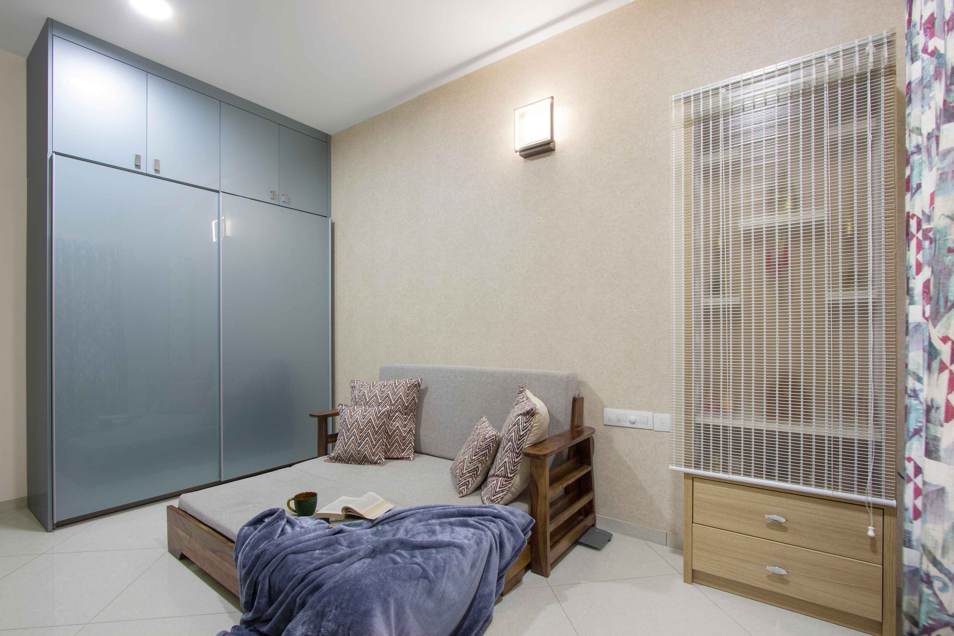 Guest Bedroom Design with Grey Sofa Cum Bed, 2-Door Sliding Wardrobe and Closed Pooja Unit - Livspace