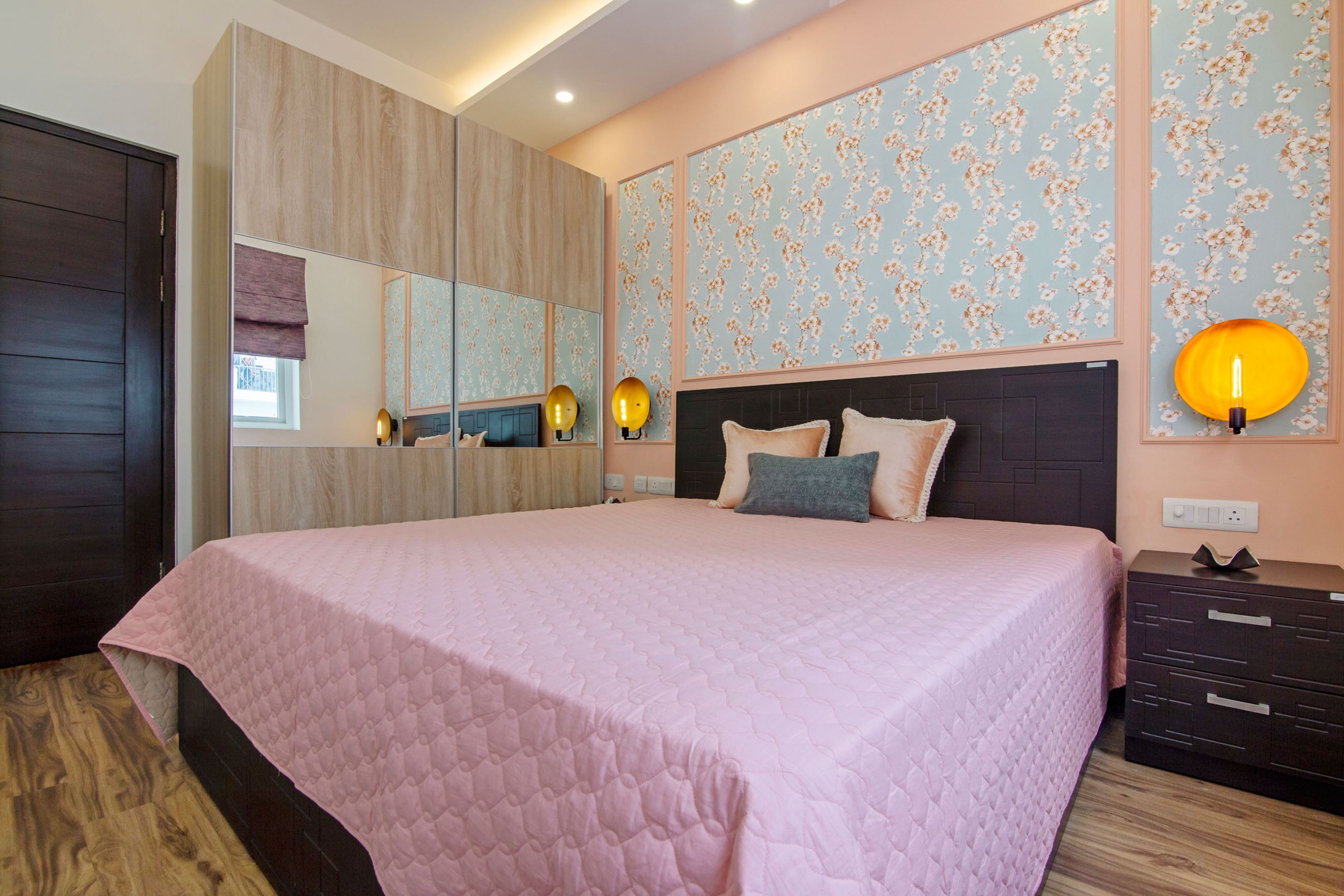 Light Pink Guest Bedroom With Floral Wall Panels And 2-Door Wooden Sliding Wardrobe With Mirrors - Livspace