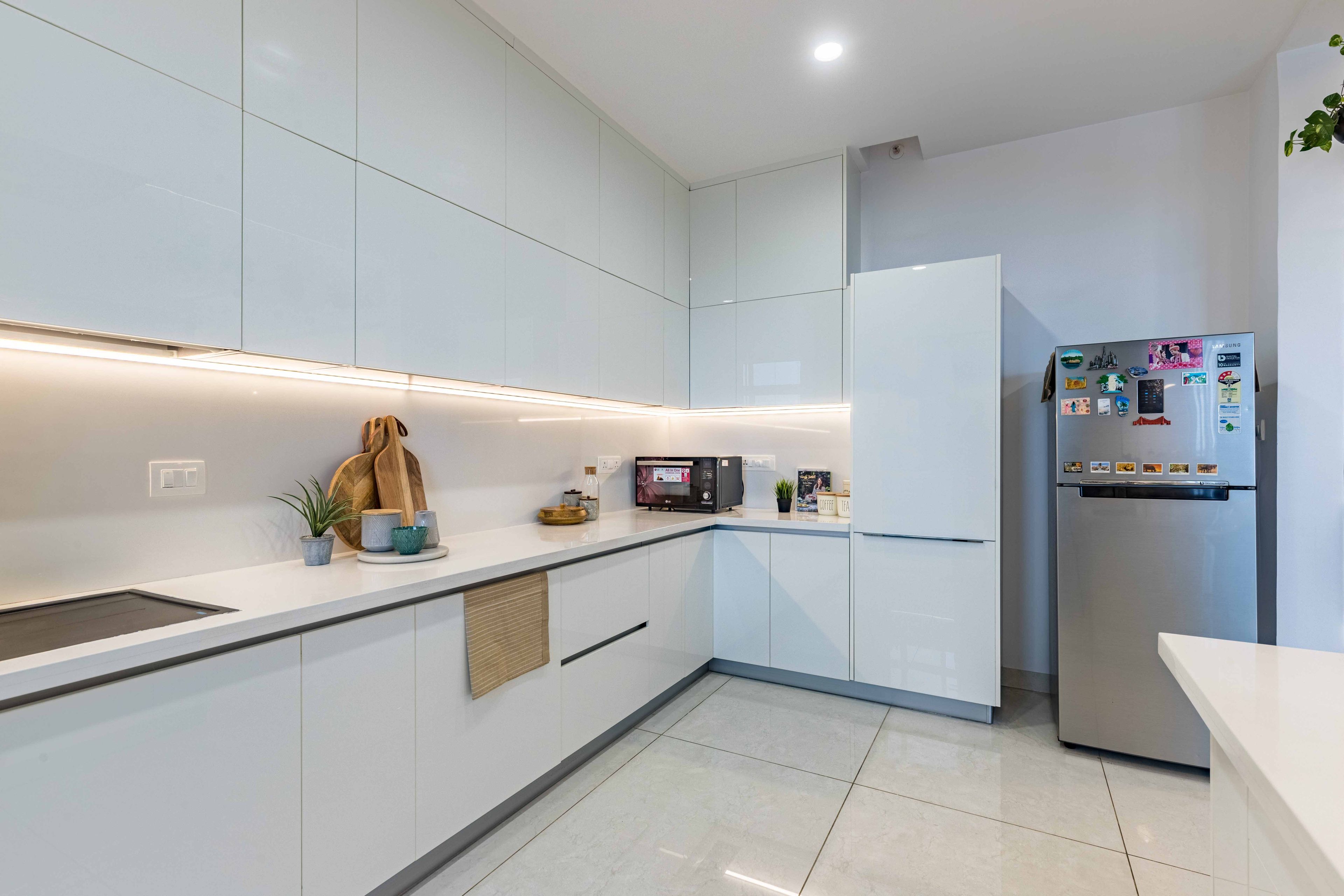 Indian L Shaped White Kitchen Cabinets With Under-Cabinet Lighting - Livspace
