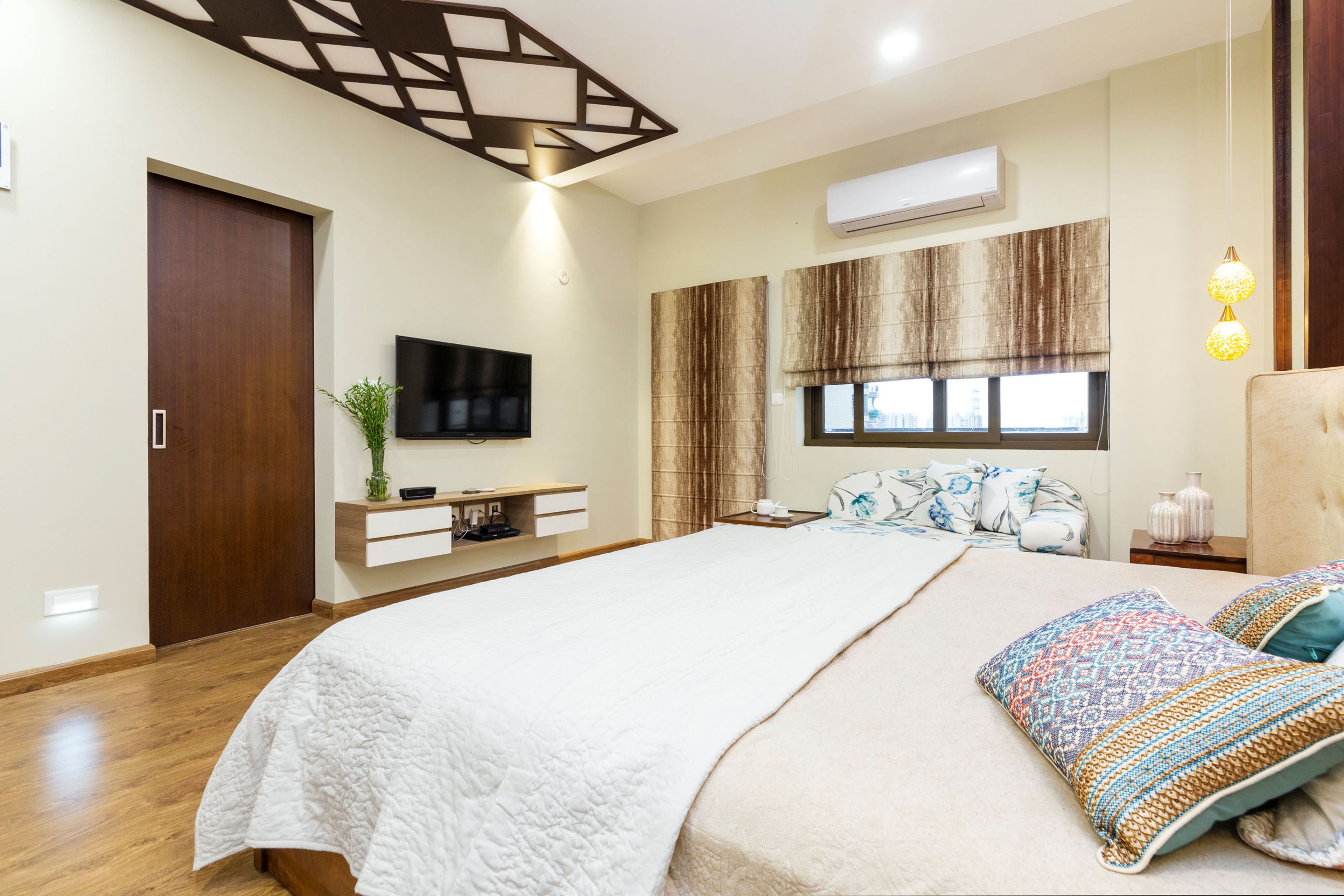 Contemporary Beige Master Bedroom With Wall-Mounted White And Wood TV Console - Livspace