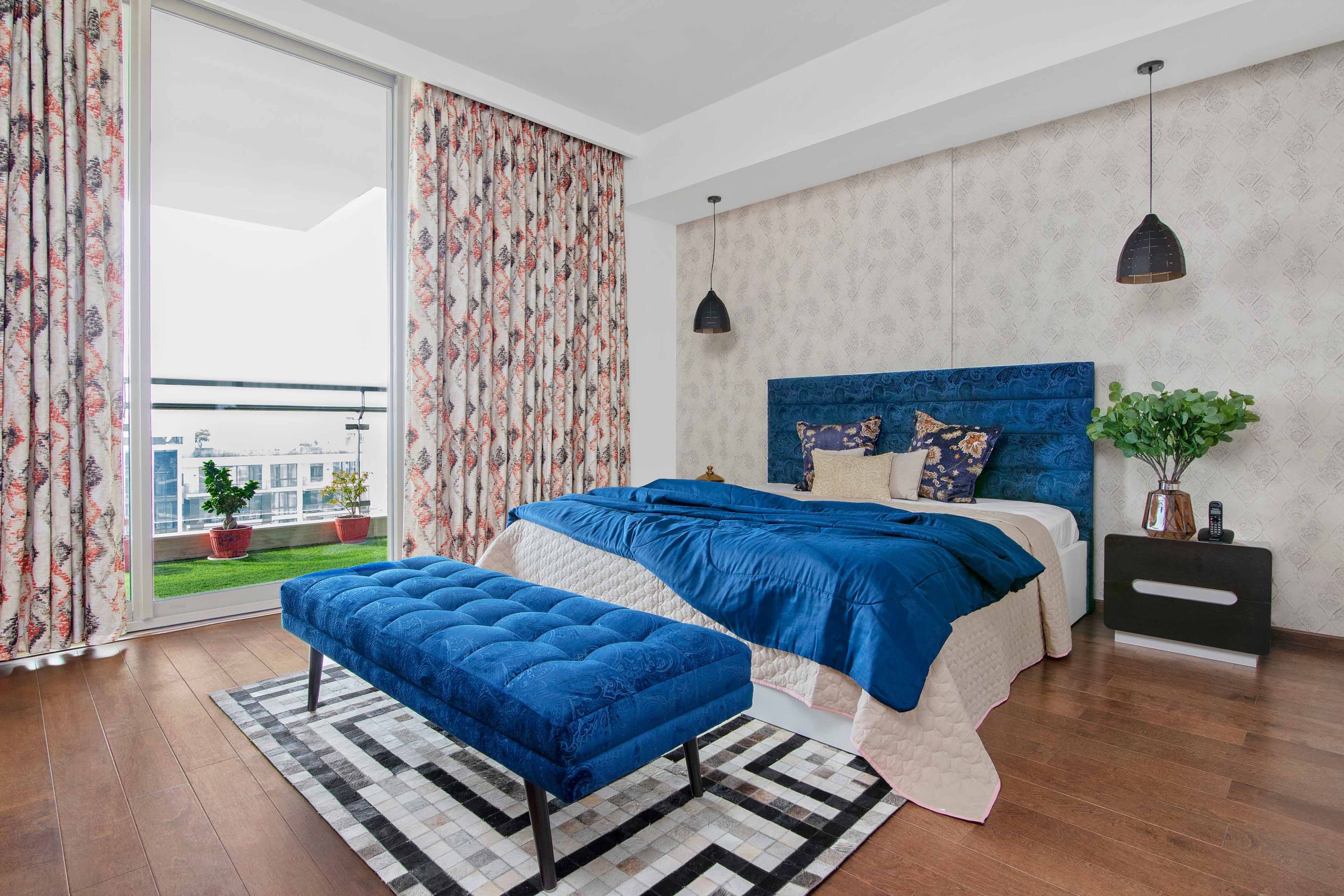 Master Bedroom Design With Blue Bed And Bench, Black And White Side Tables And Damask Wallpaper In Beige - Livspace