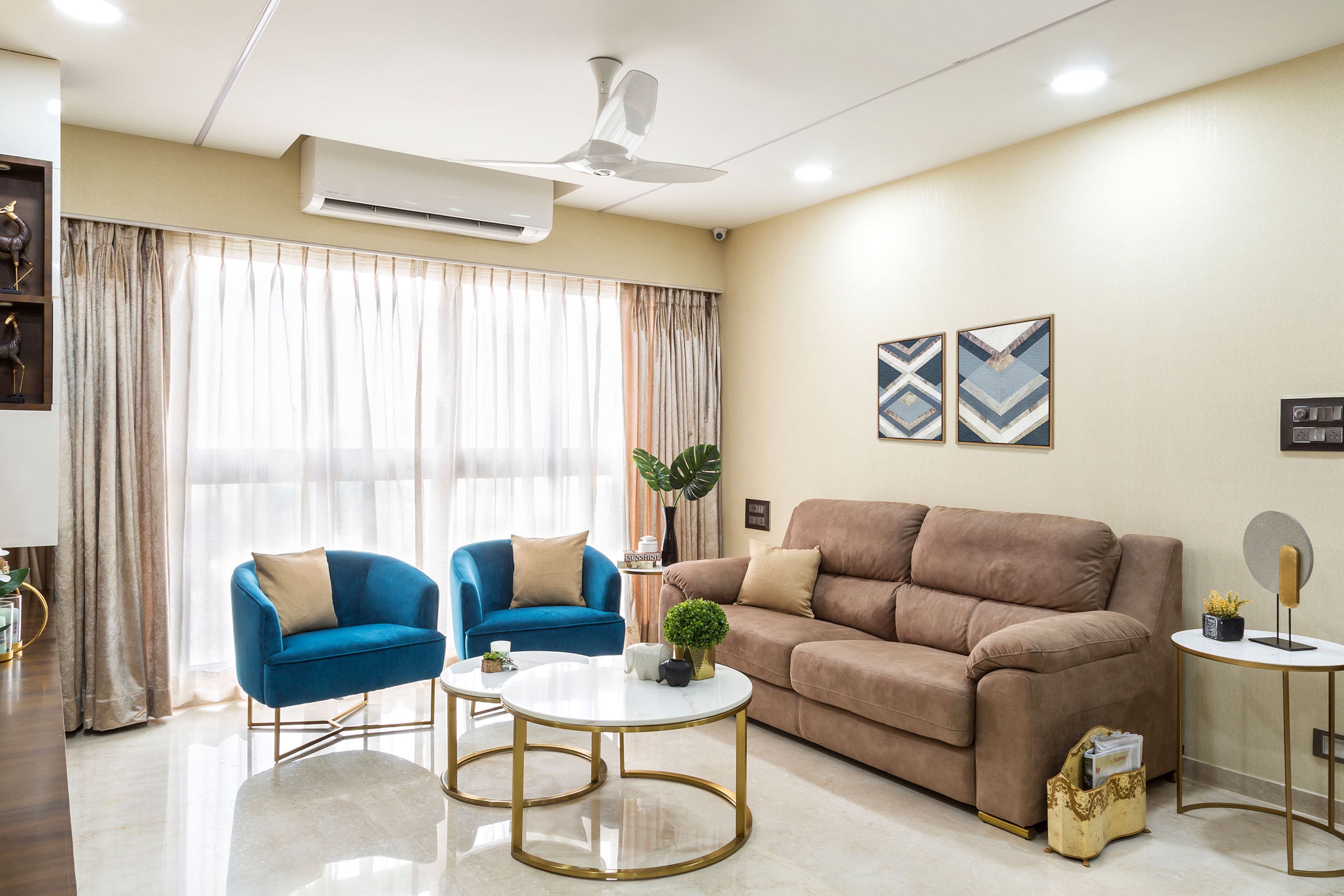 2-seater brown sofa with blue accent chairs - Livspace