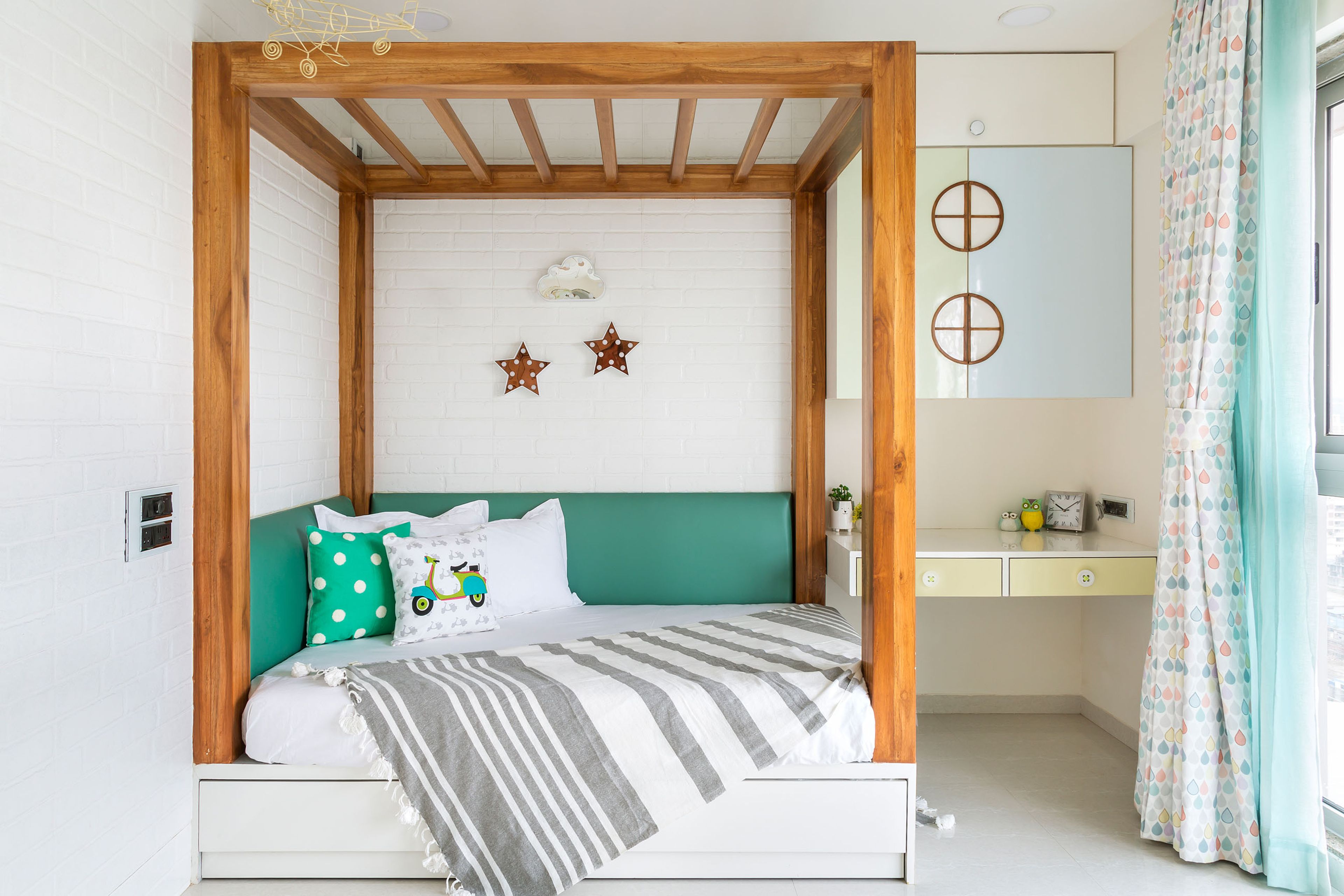 Kids room with wooden 4-poster bed and wall-mounted study table - Livspace