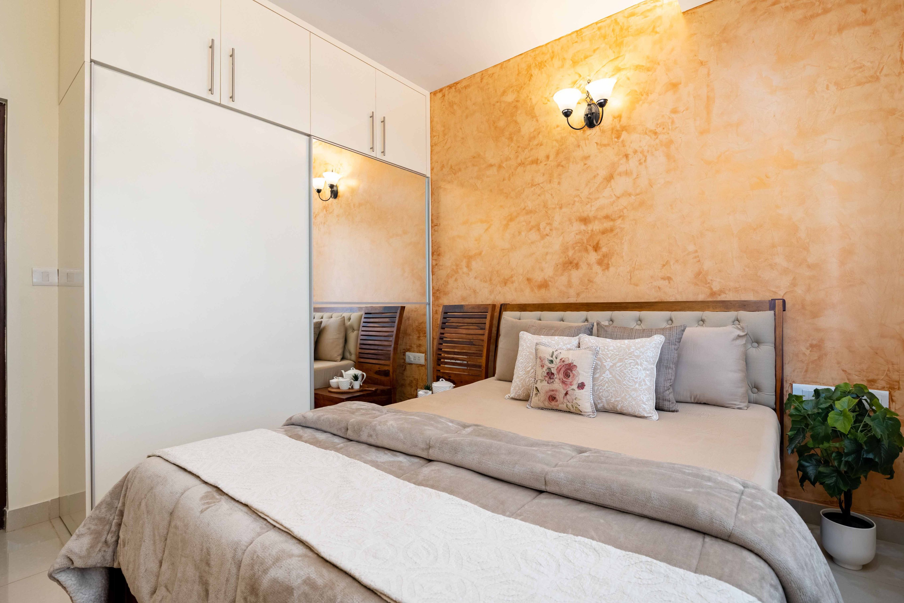 Guest bedroom with wooden bed and 2-door sliding wardrobe with mirror in white - Livspace