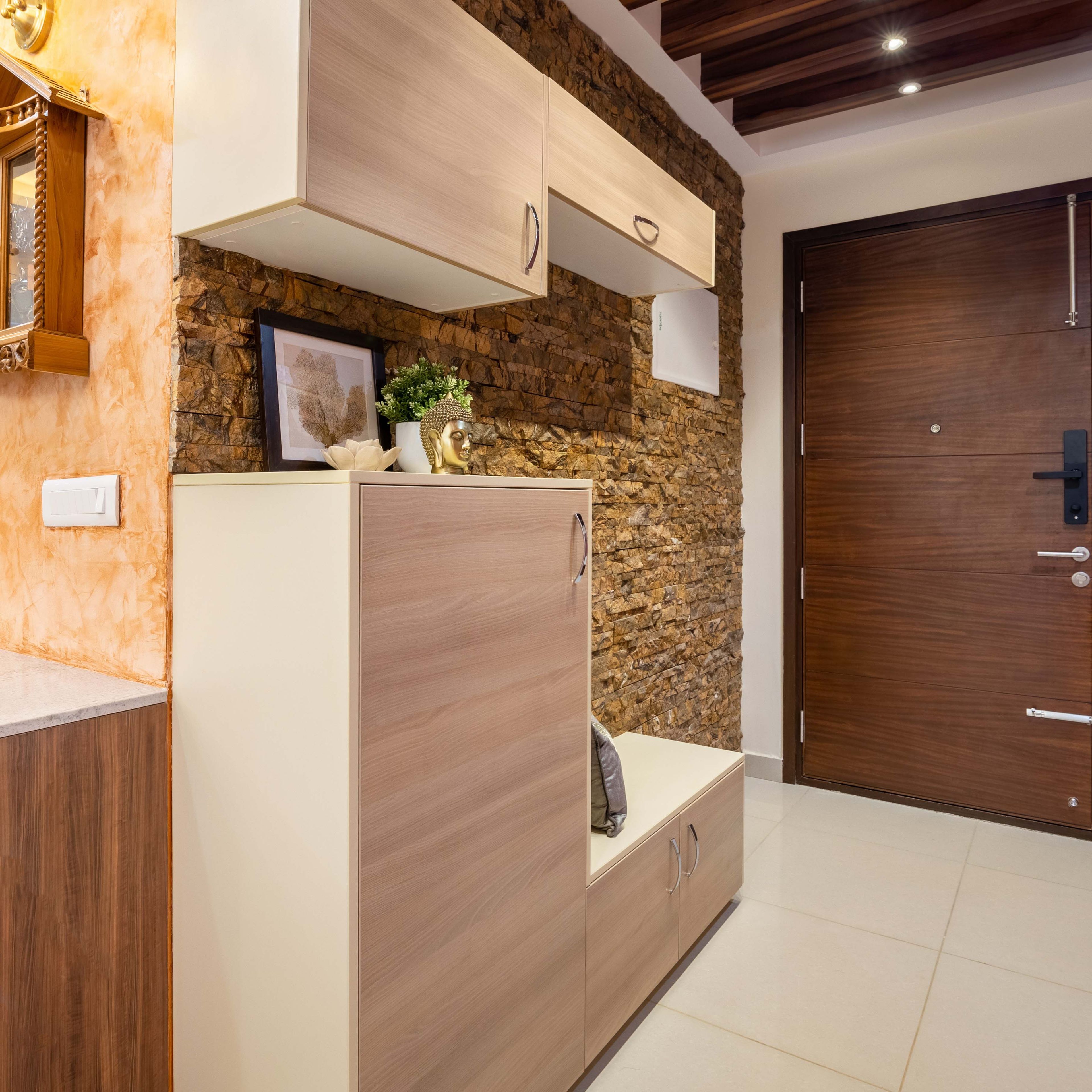 Wooden foyer design with brick wall - Livspace