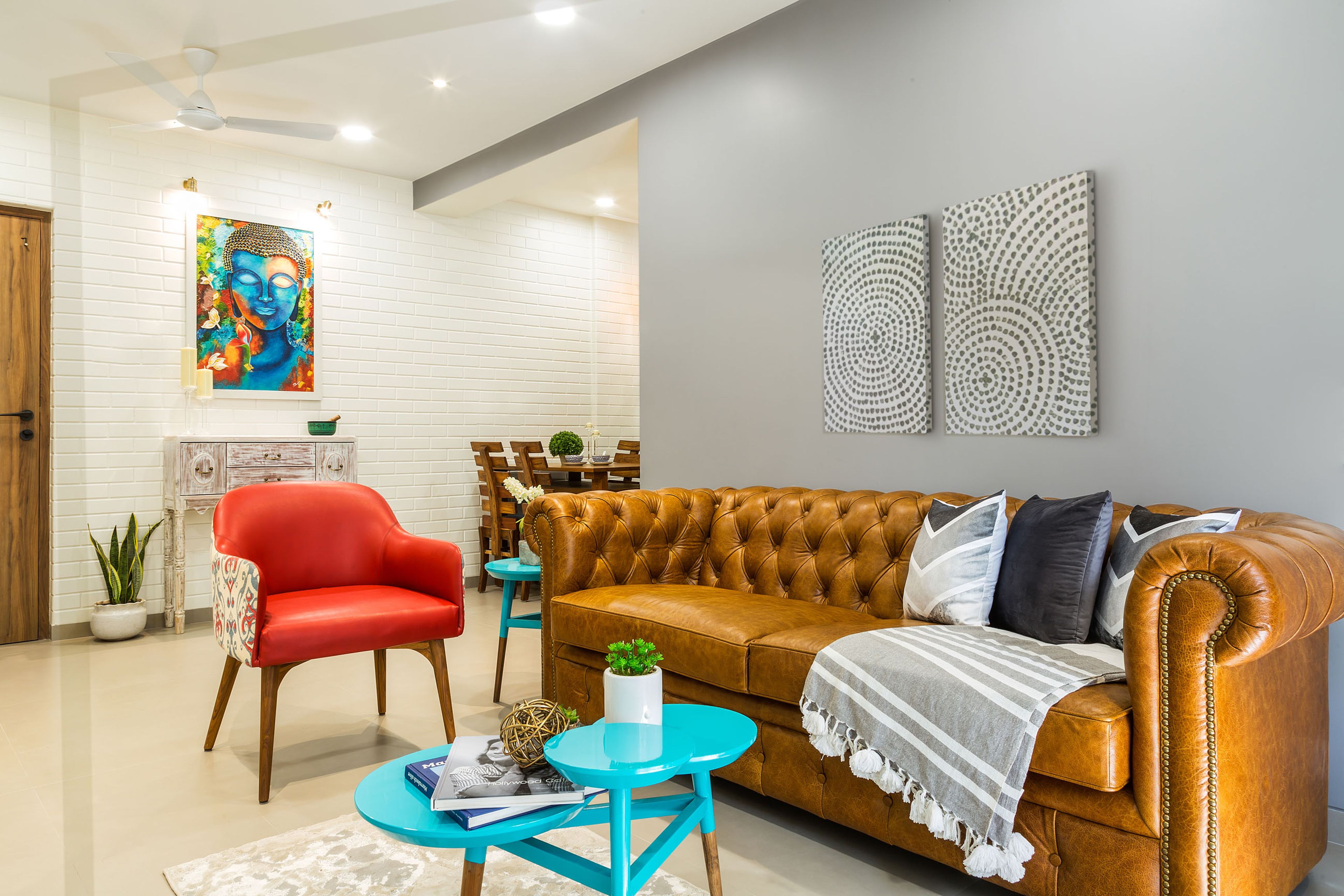 3-seater chesterfield tan brown sofa, red accent chair and blue coffee table - Livspace