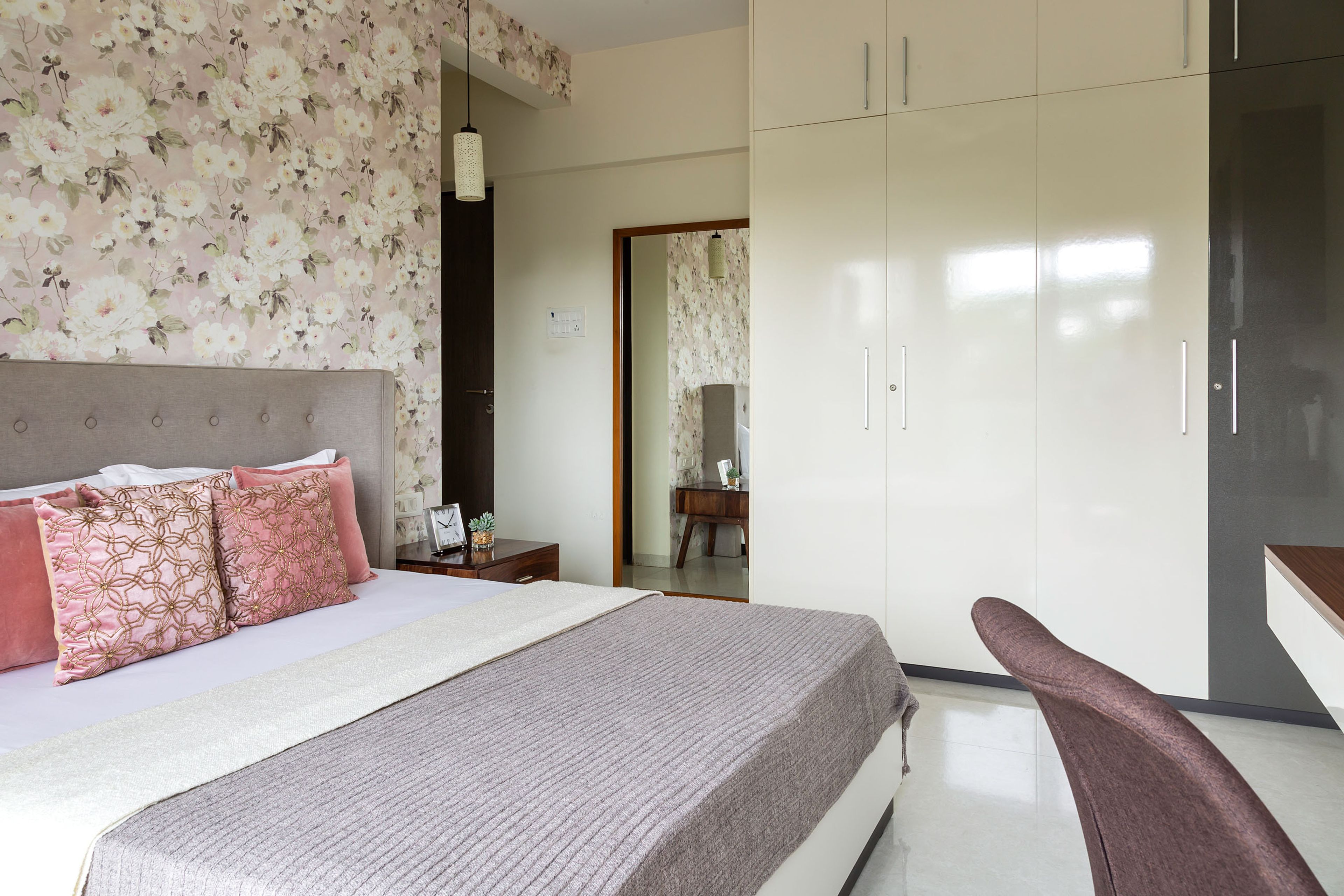 Master bedroom with 4-door swing wardrobe in grey and white with loft - Livspace