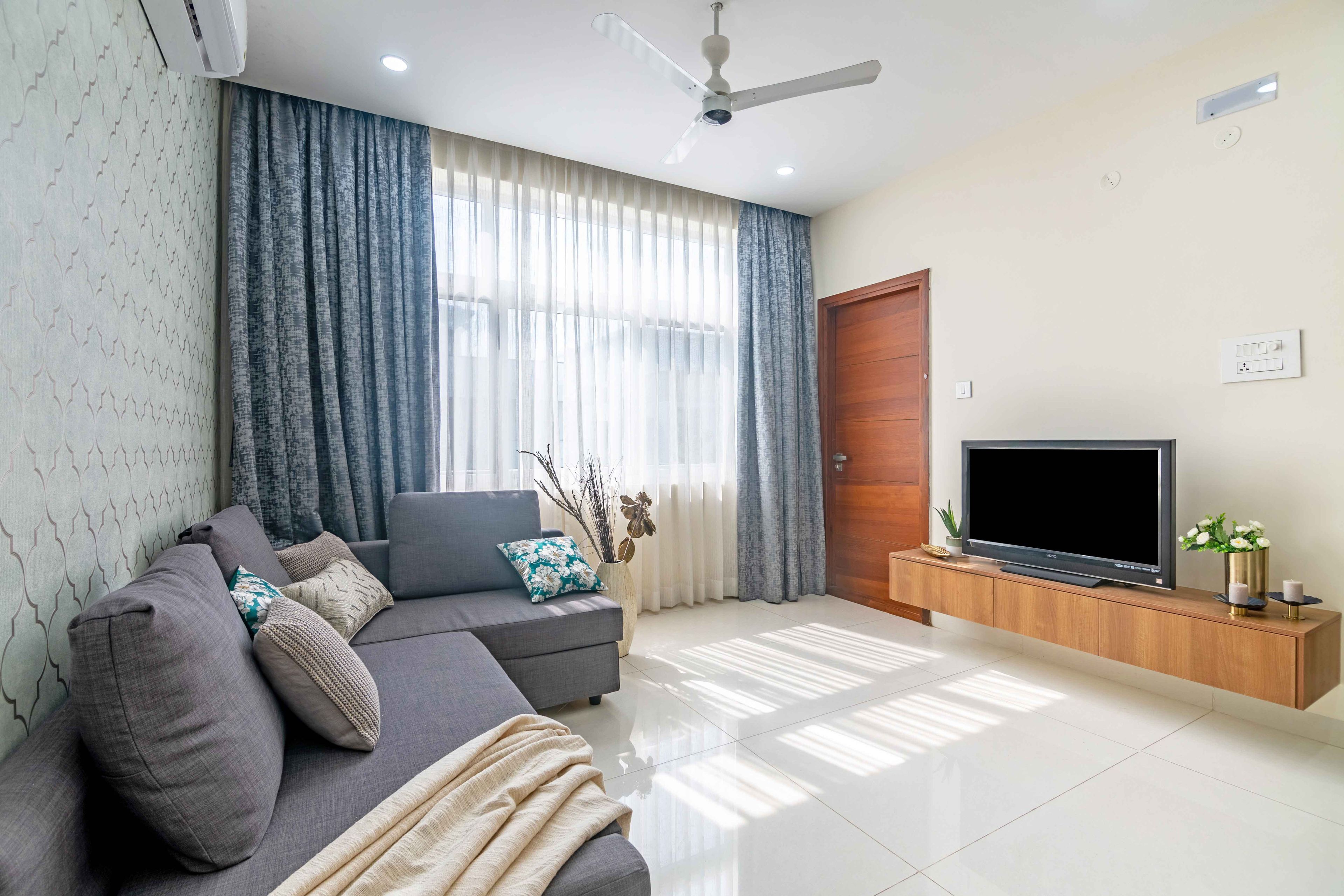 Floating wooden tv unit with grey sofa - Livspace