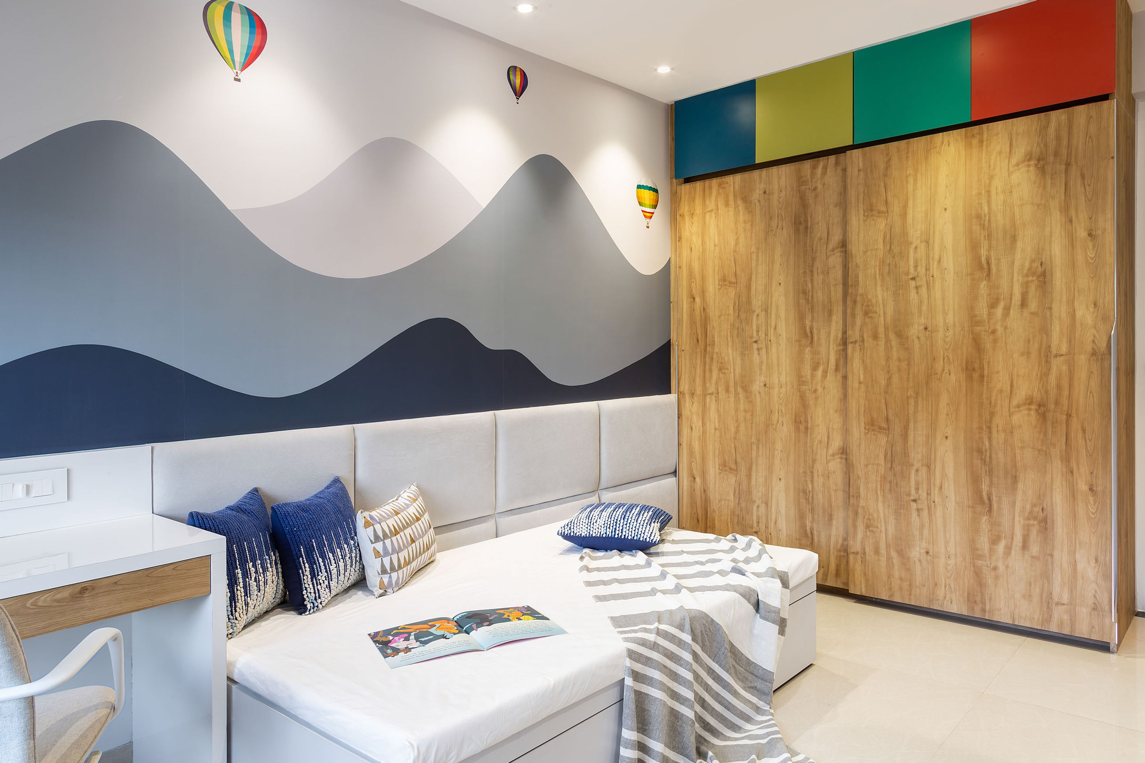 Kids bedroom with white tufted headboard and 2-door sliding wardrobe with multicolour loft - Livspace