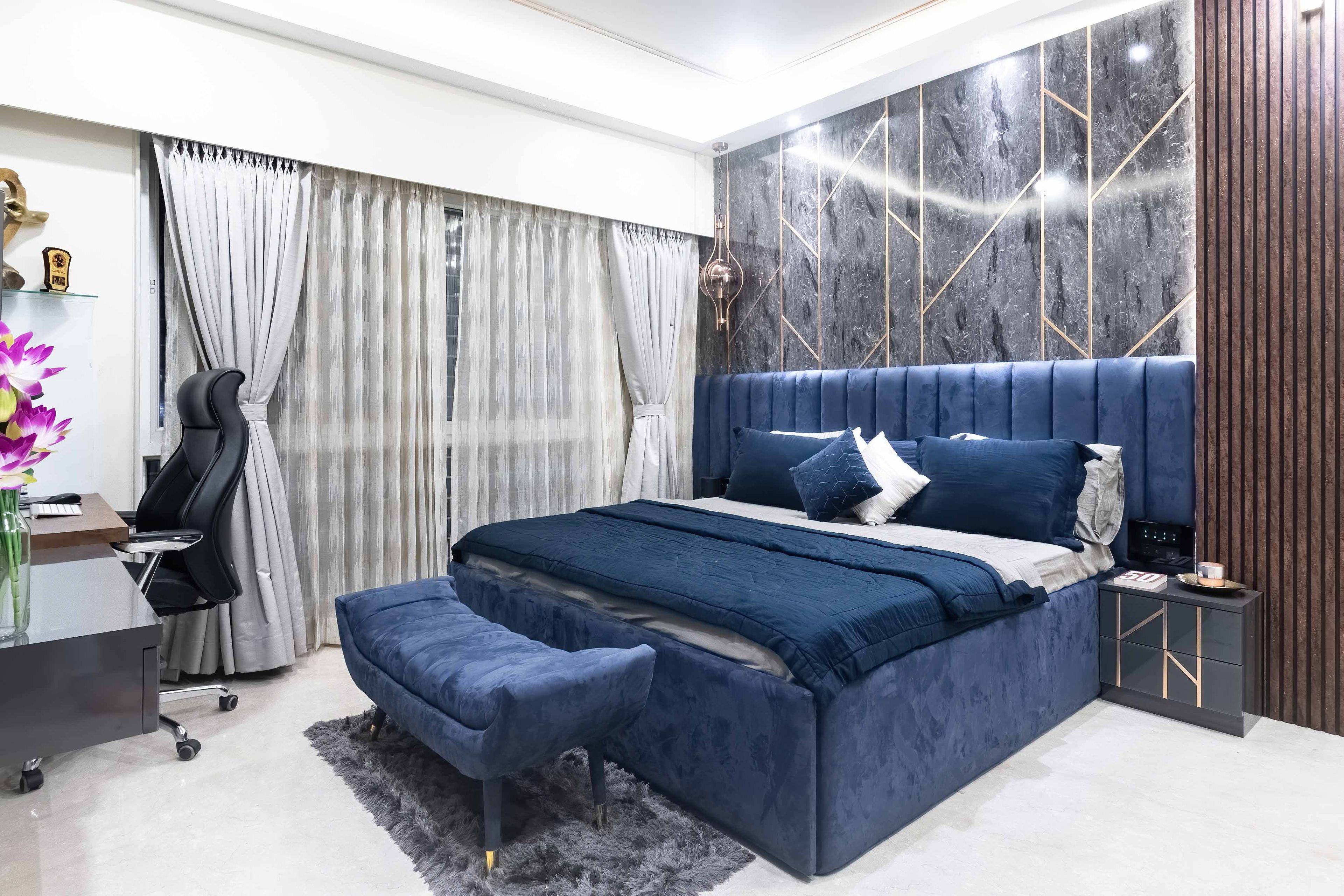 Master bedroom with royal blue bed and study table - Livspace