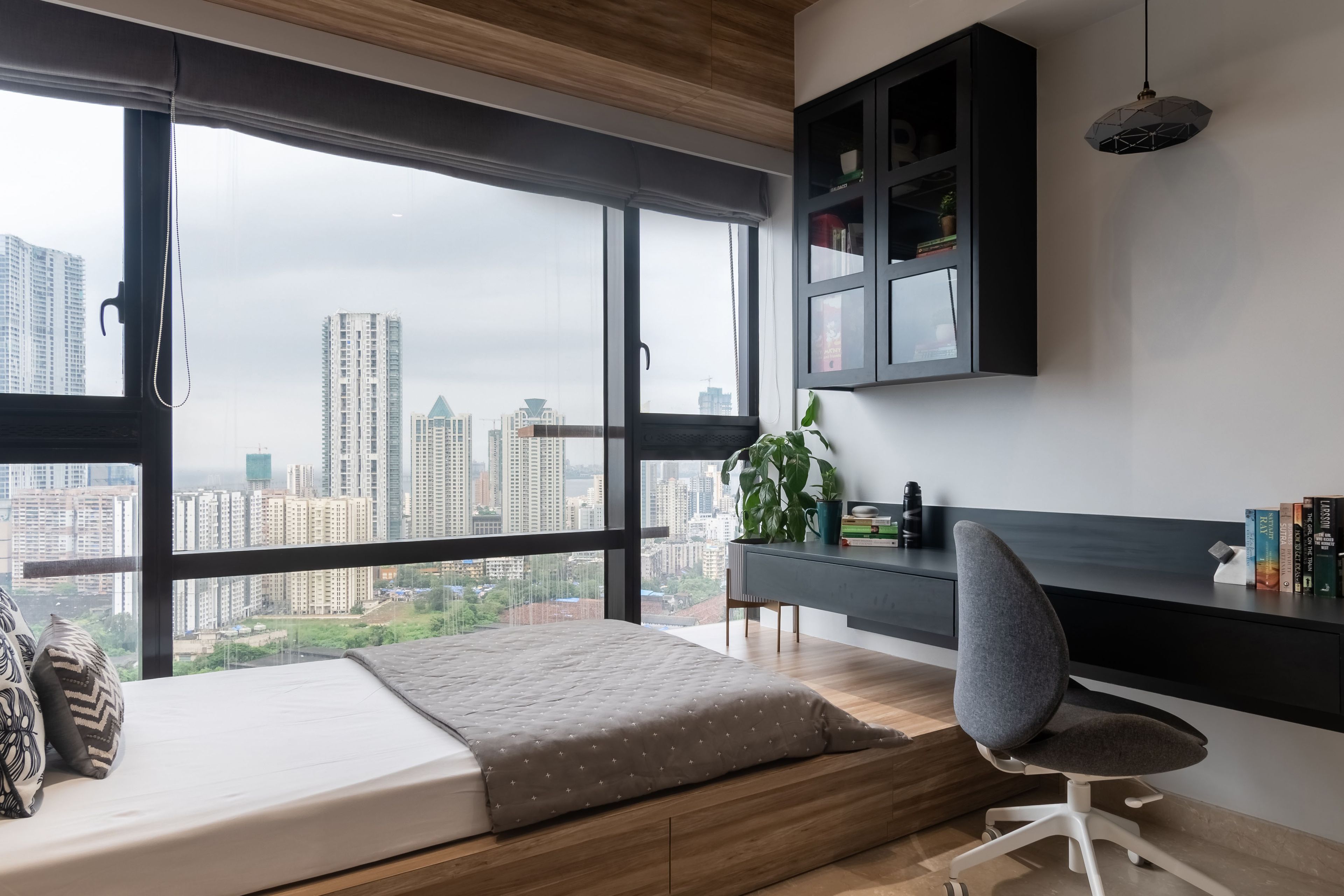 Dark grey wall-mounted study table with large window for natural light - Livspace