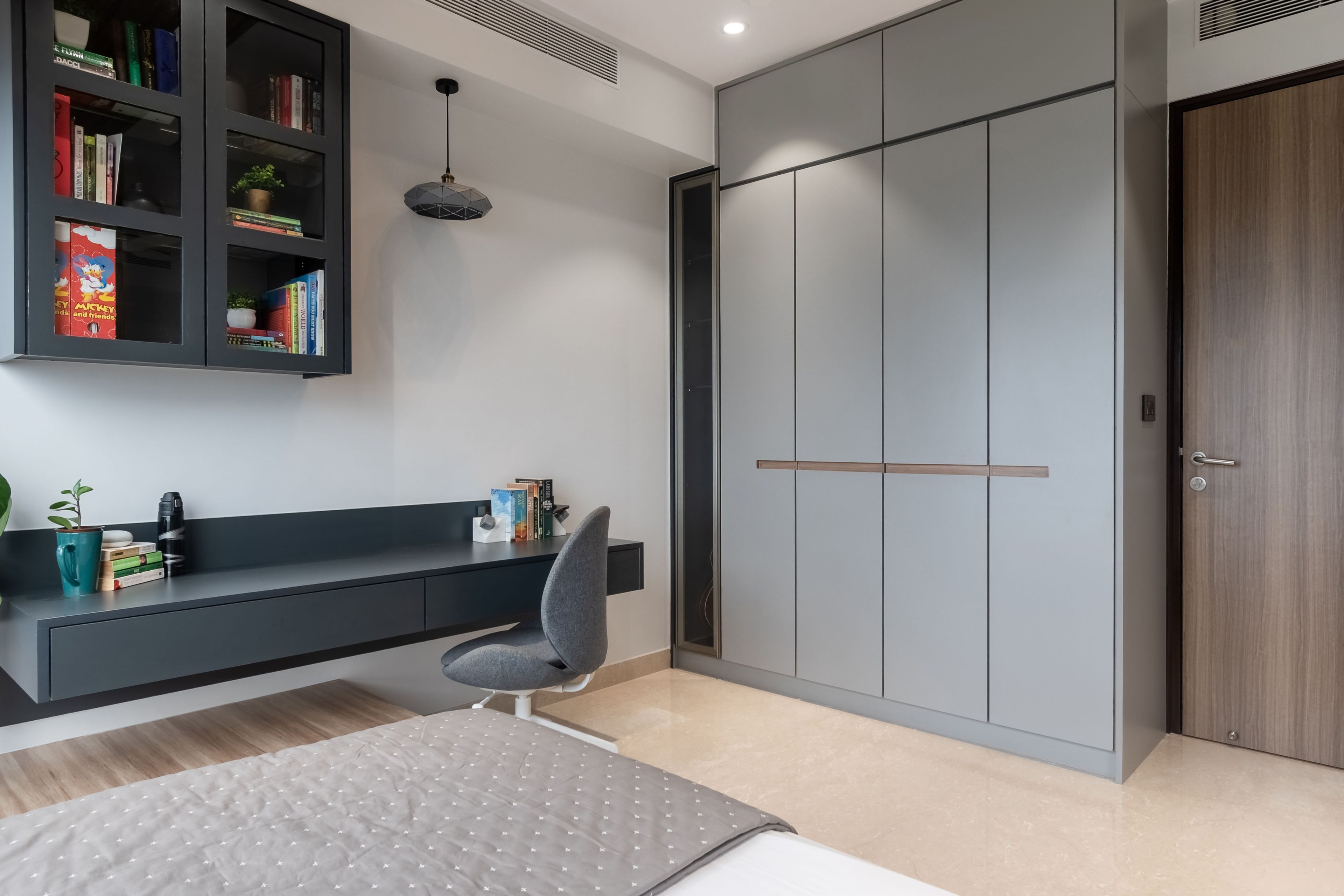 4-door grey swing wardrobe with loft storage and wall-mounted study table with storage - Livspace