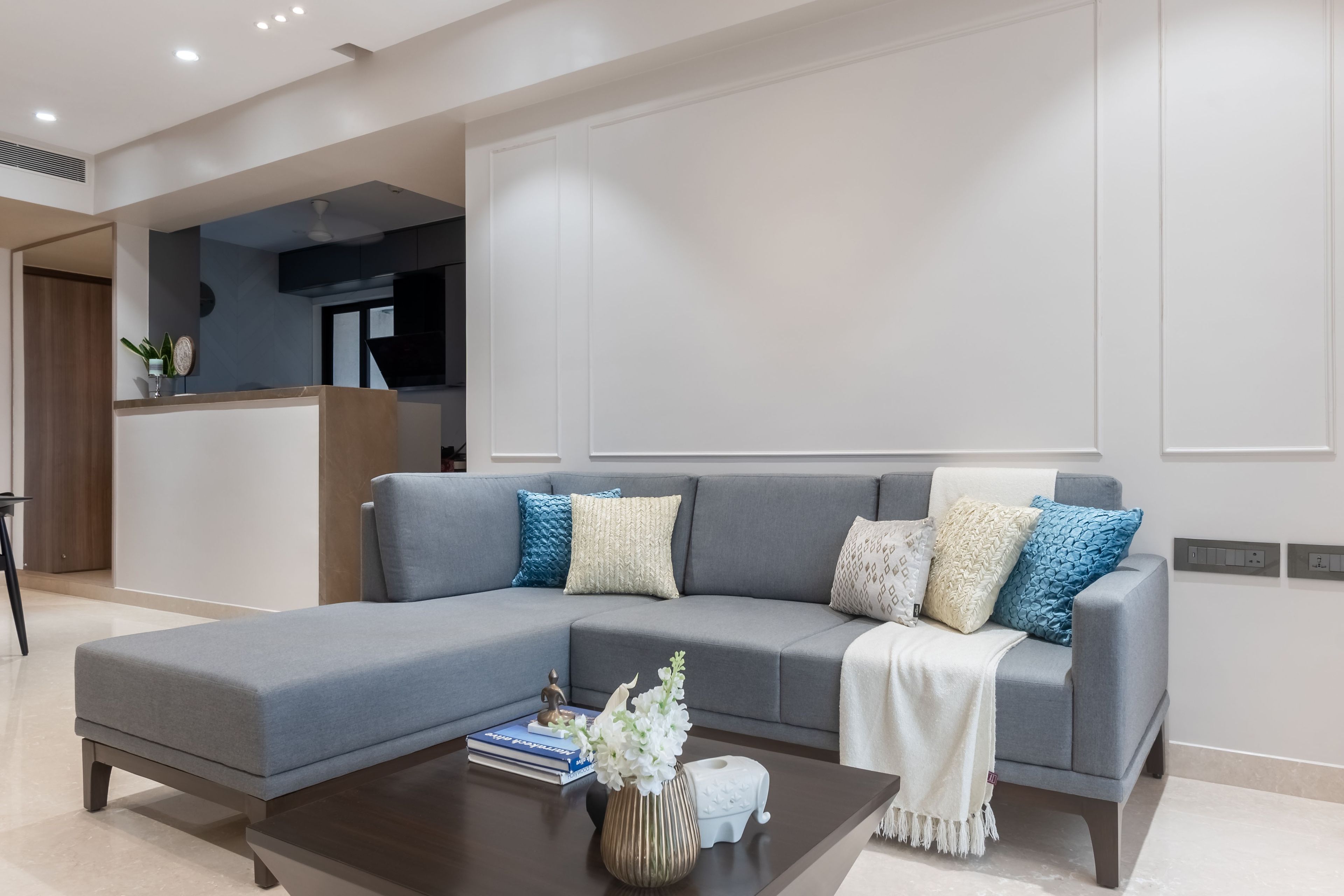 Grey sectional sofa with blue and white cushions - Livspace