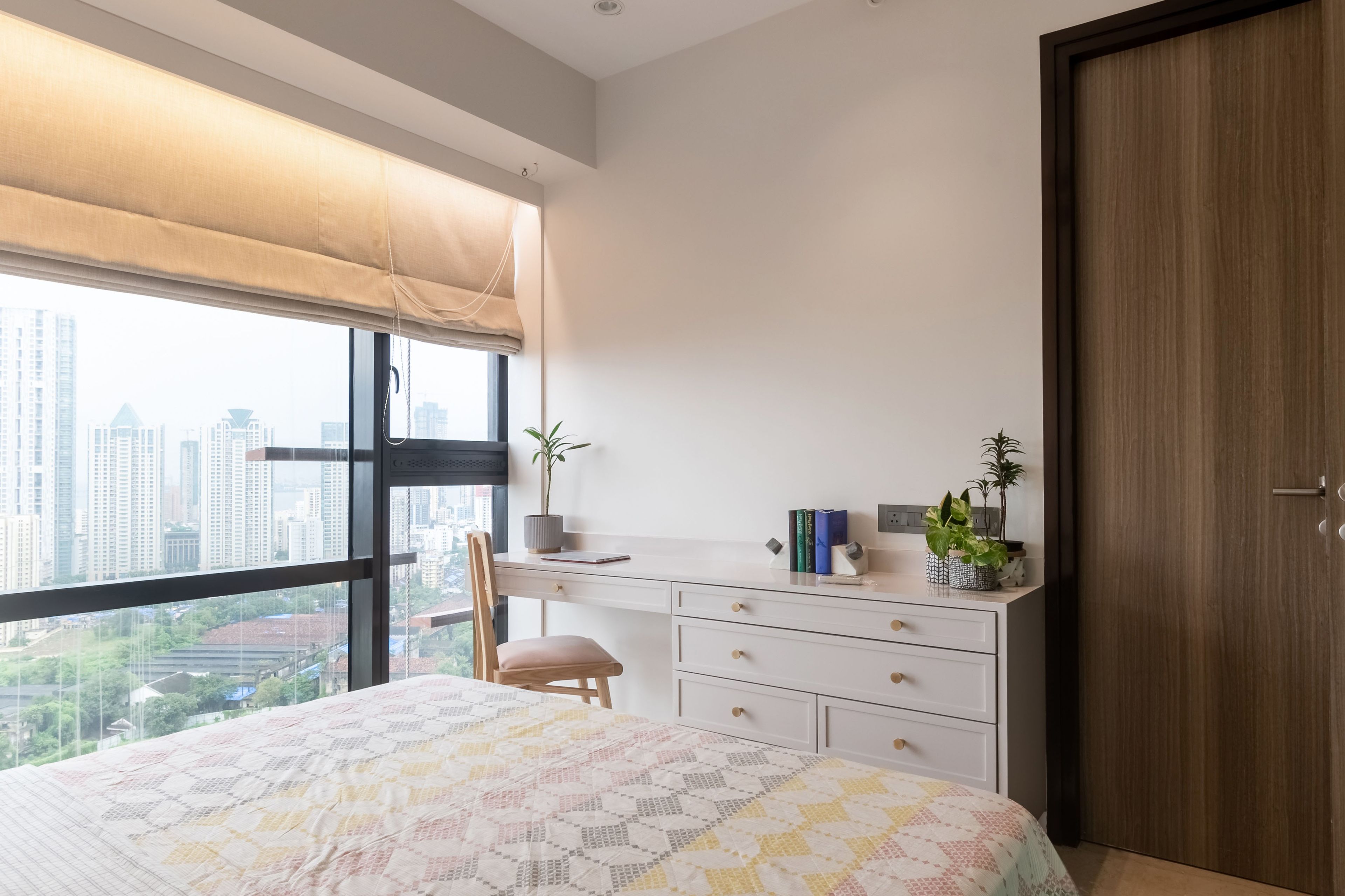 White study table with light pink and wood accent chair - Livspace