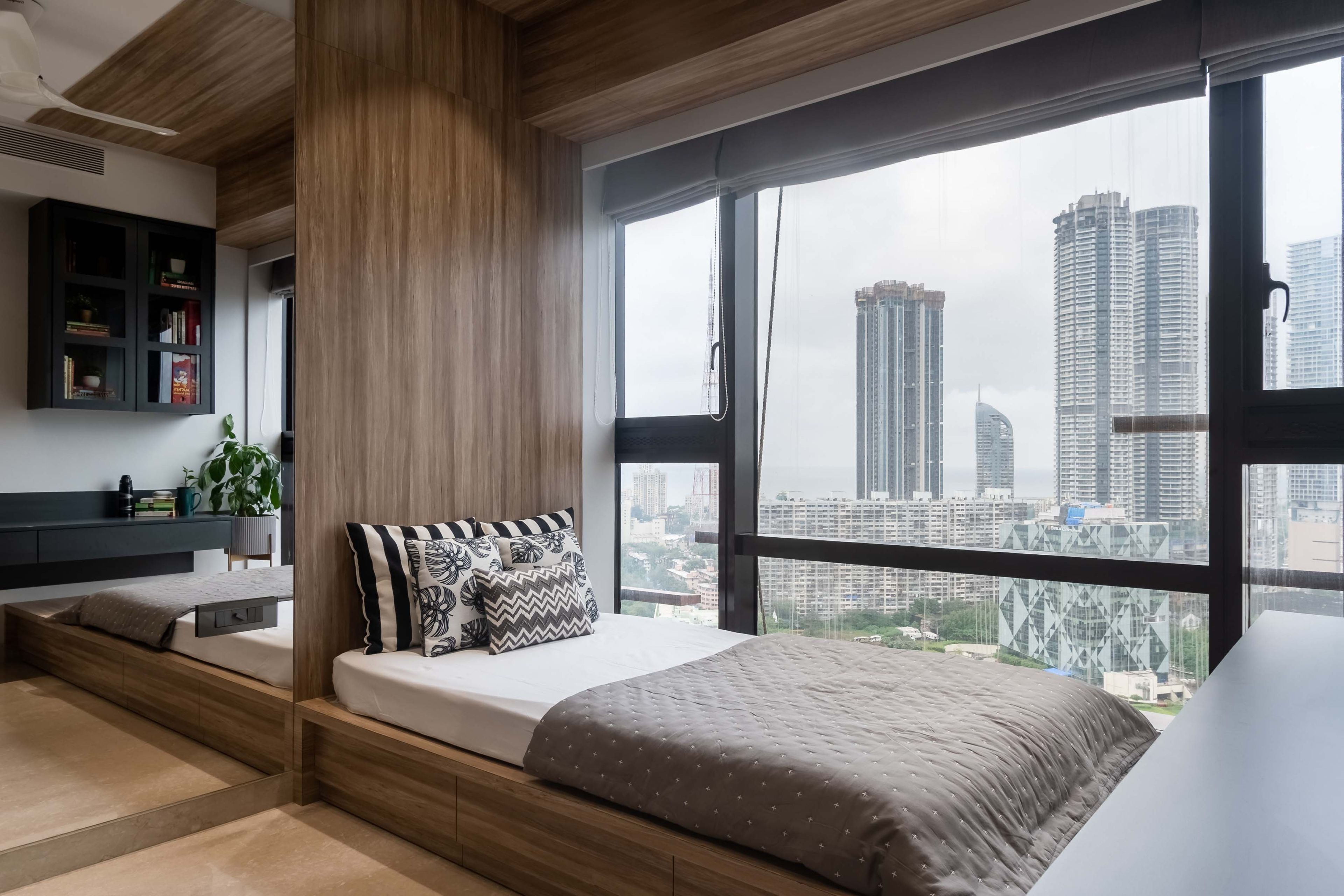 Wood and grey bed with floor-to-ceiling wooden headboard and mirror - Livspace