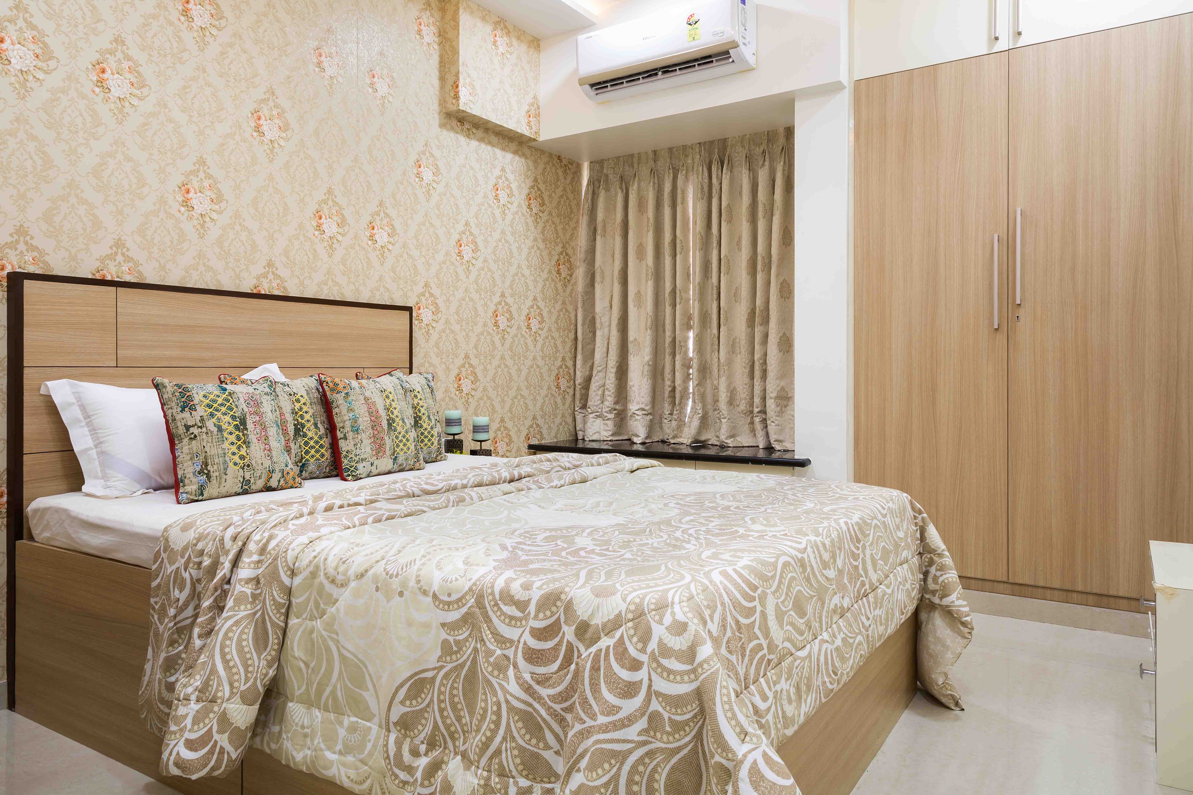 Master bedroom with wooden bed and beige damask wallpaper - Livspace