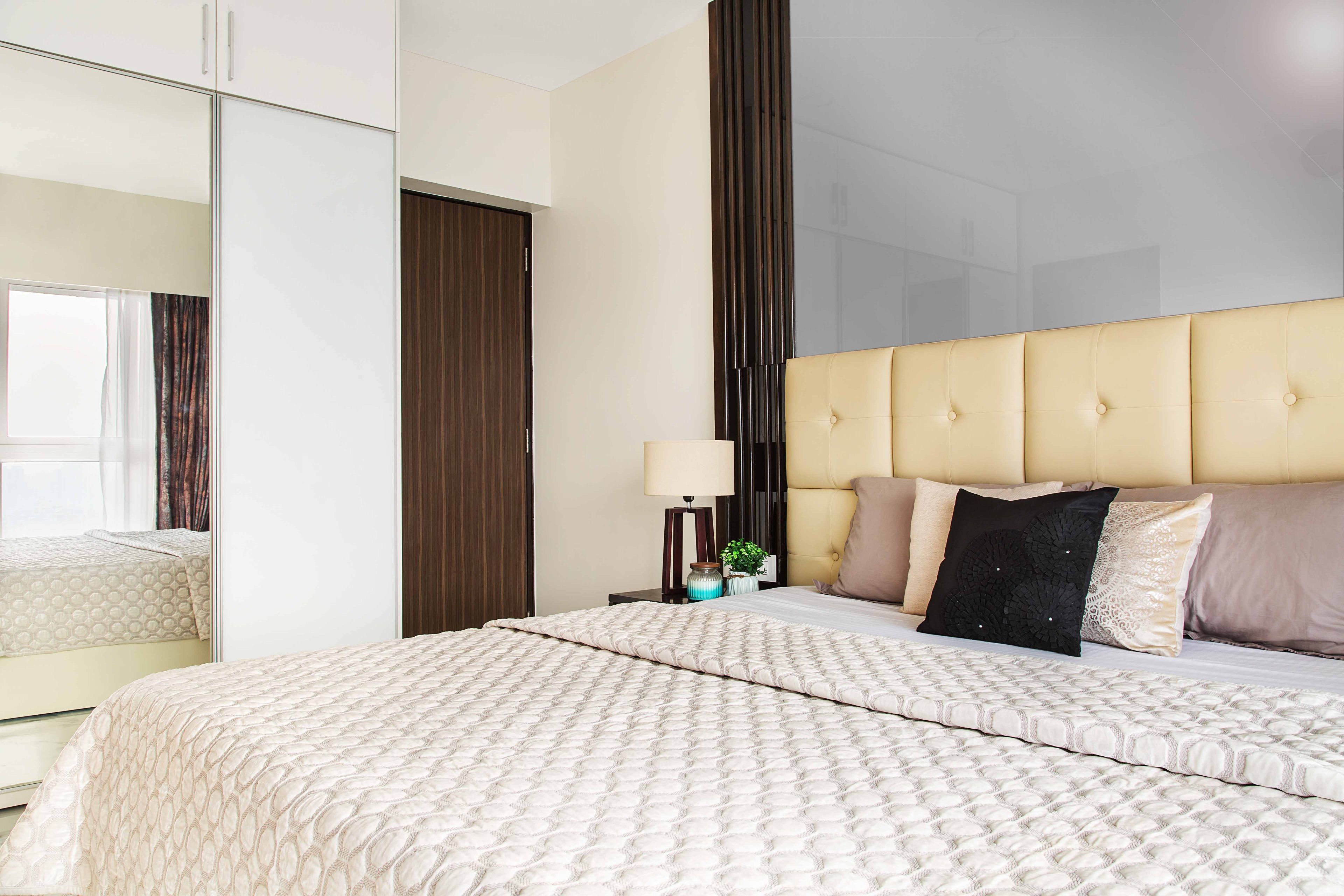 Grey and beige bedroom with beige tufted headboard - Livspace