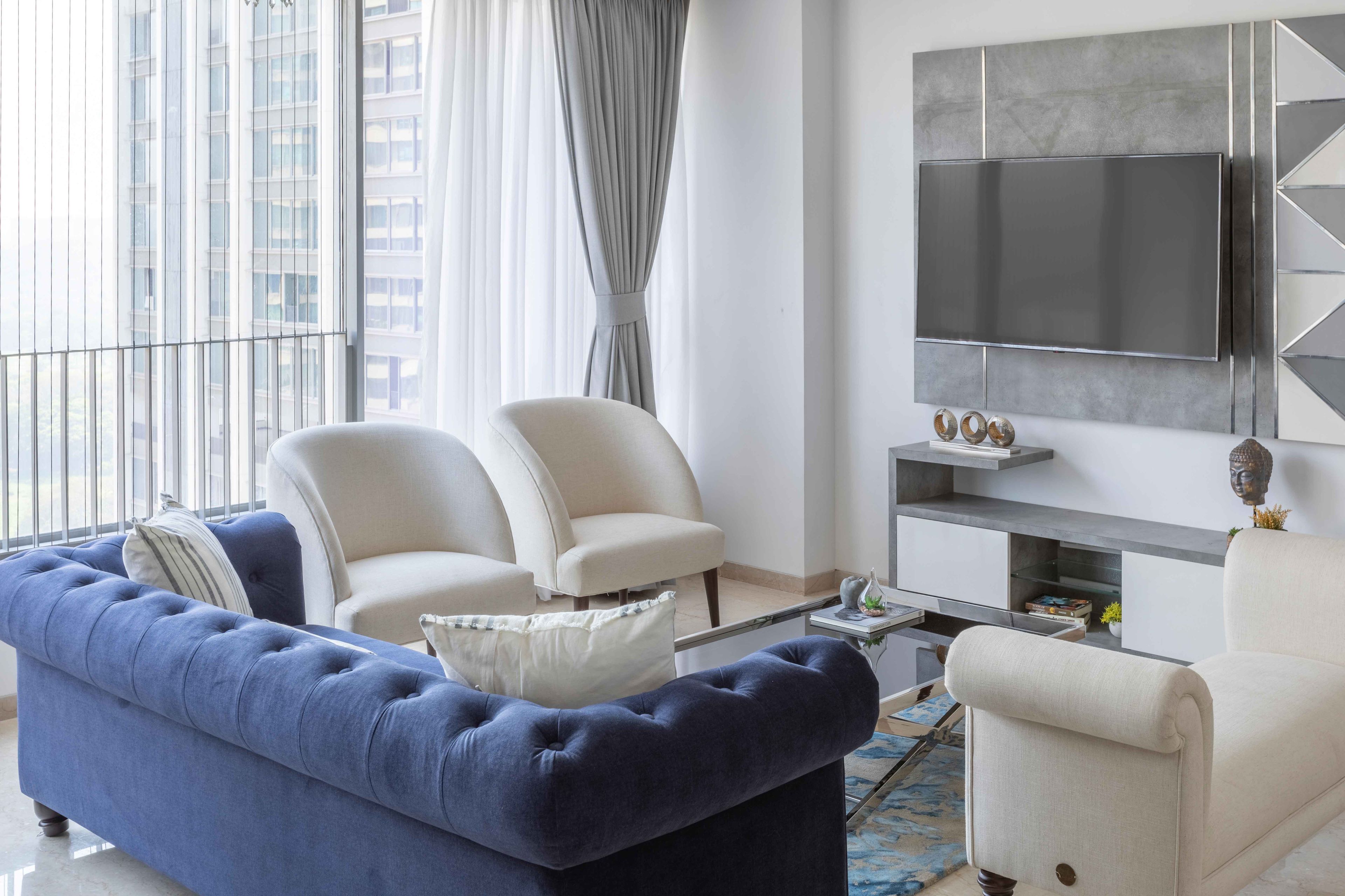 Grey and white living room with beige accent chairs and sofa - Livspace