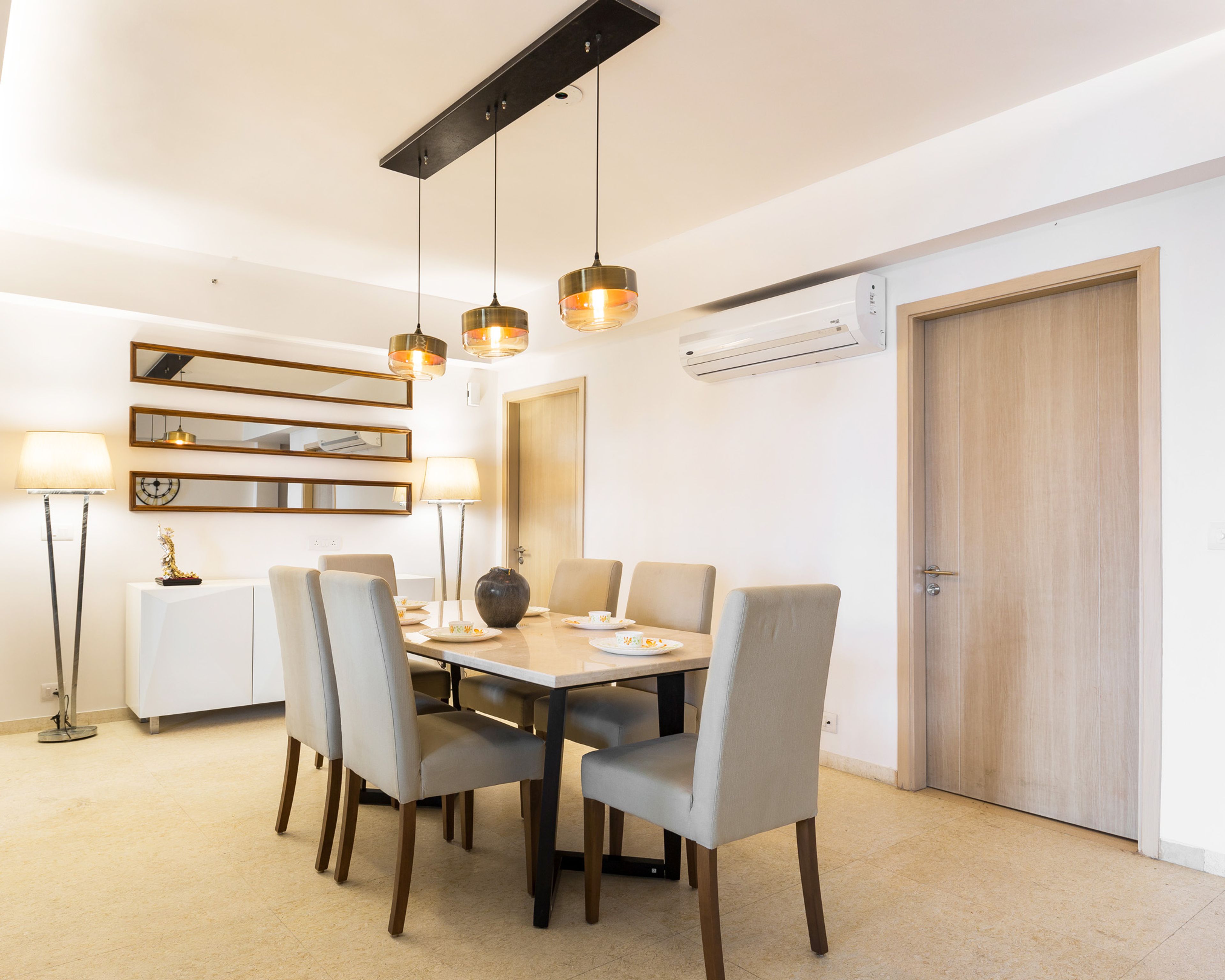 6-seater off-white and wood dining room design with drop down lights - Livspace