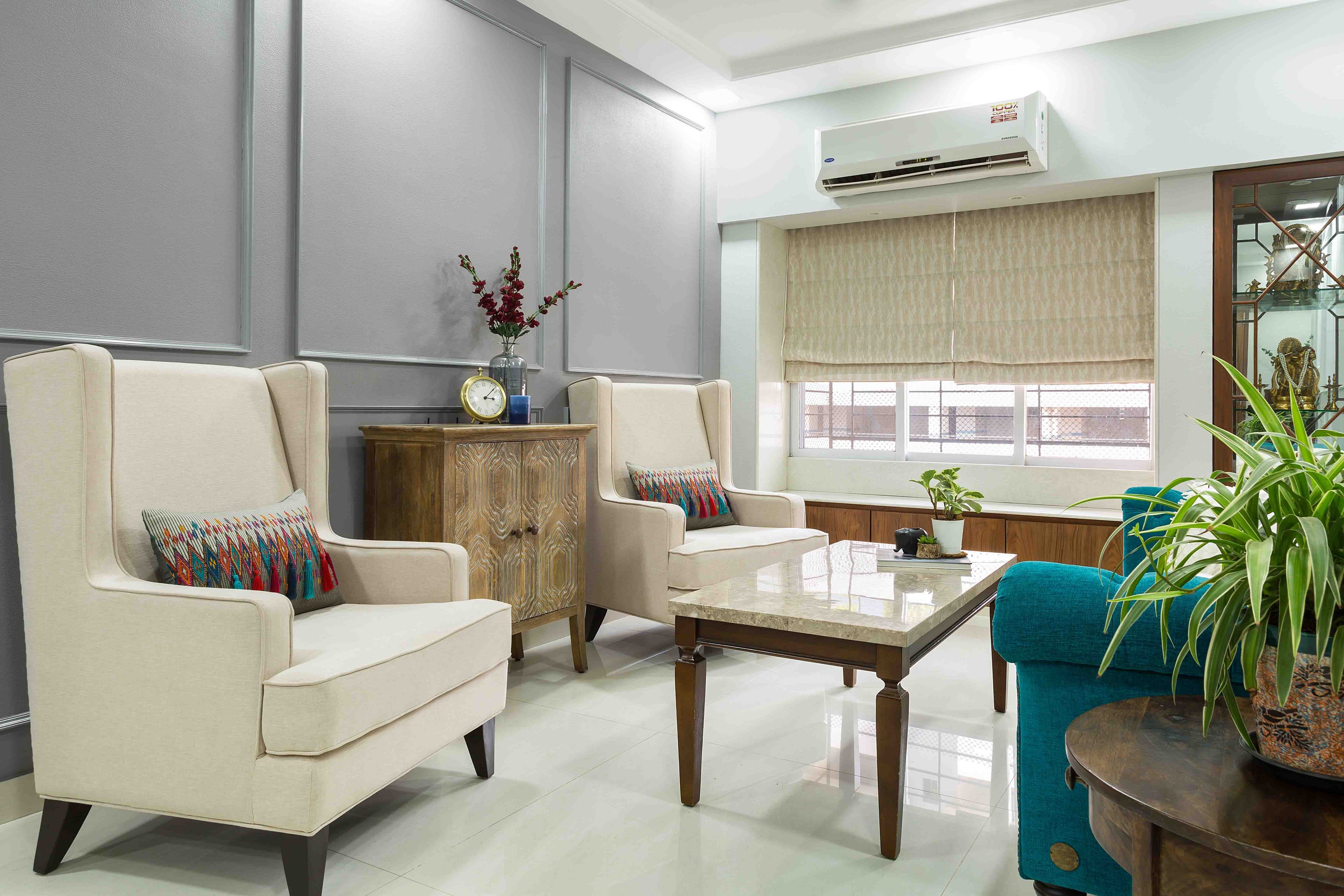 Living room with grey accent walls and beige accent chairs - Livspace
