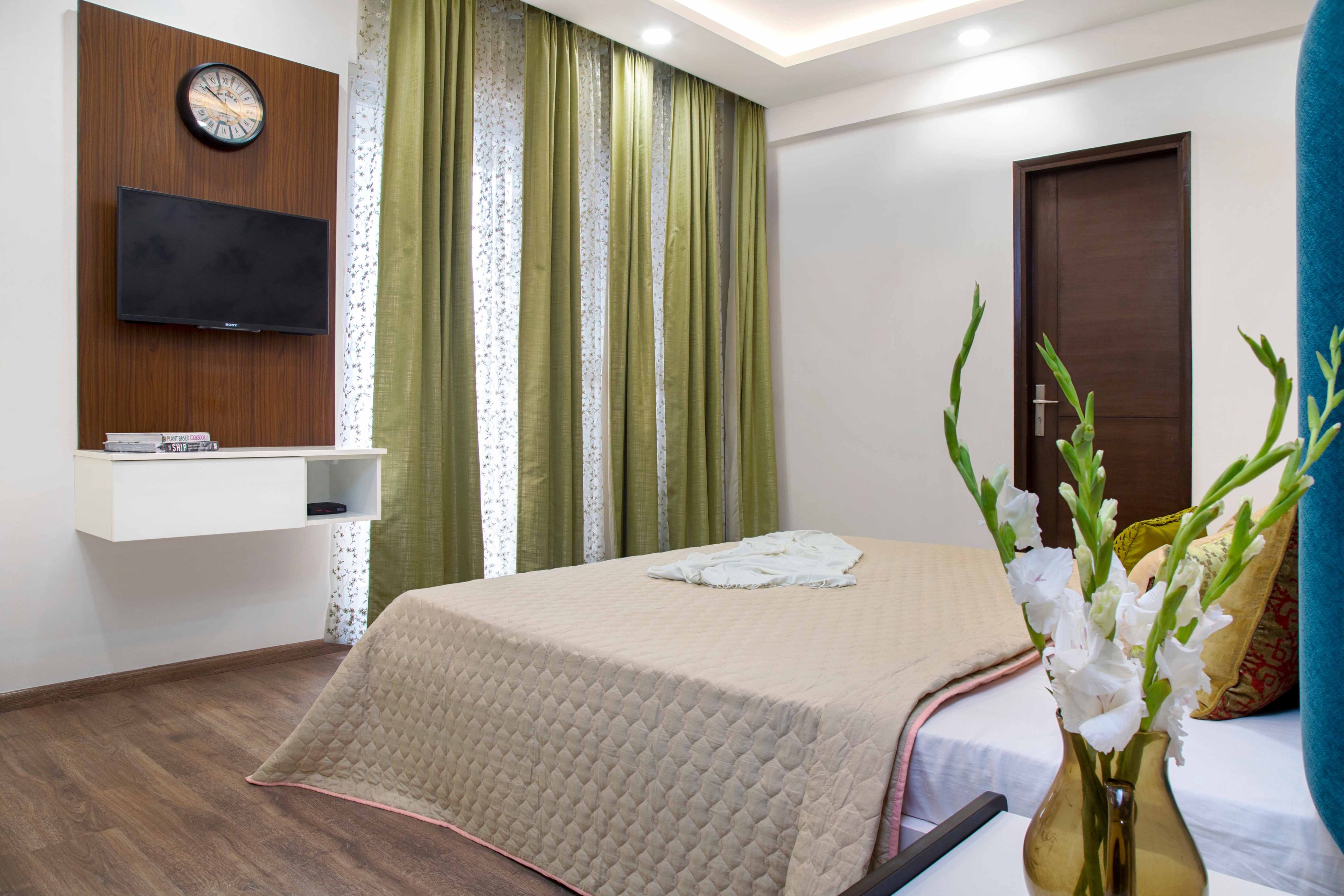 Wood and white floating TV unit for the master bedroom - Livspace