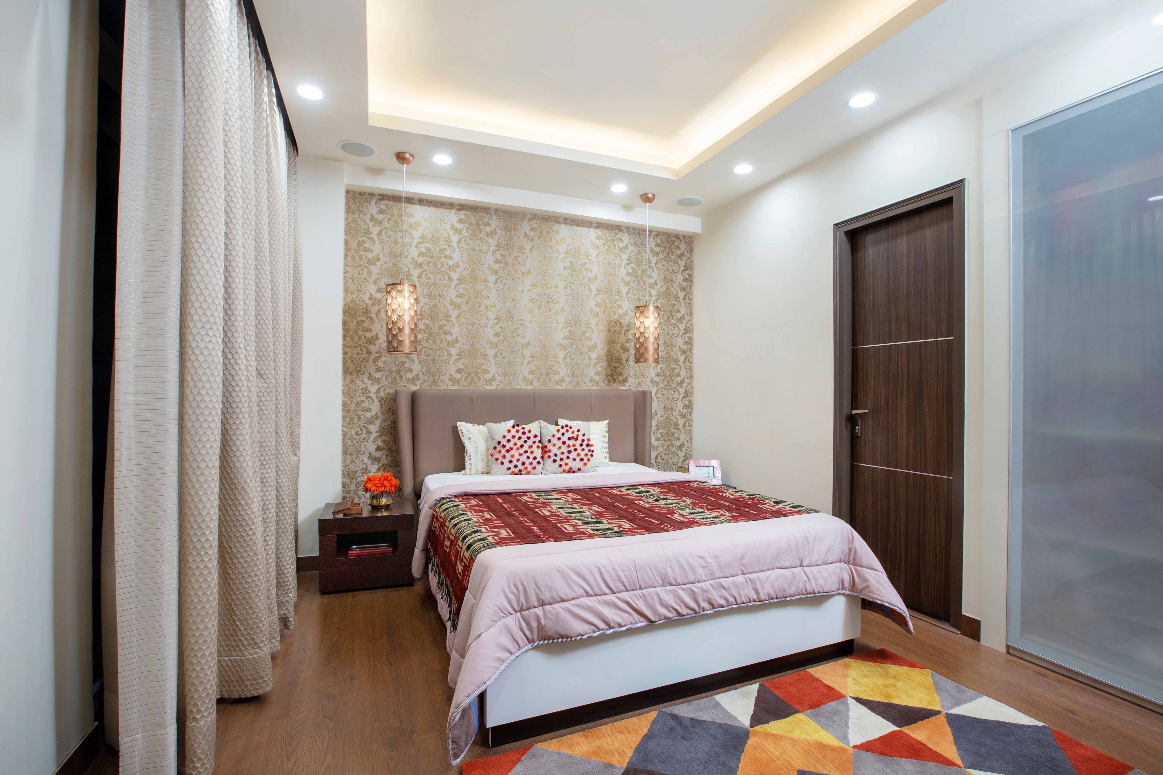 Compact beige guest room design with damask wallpaper - Livspace