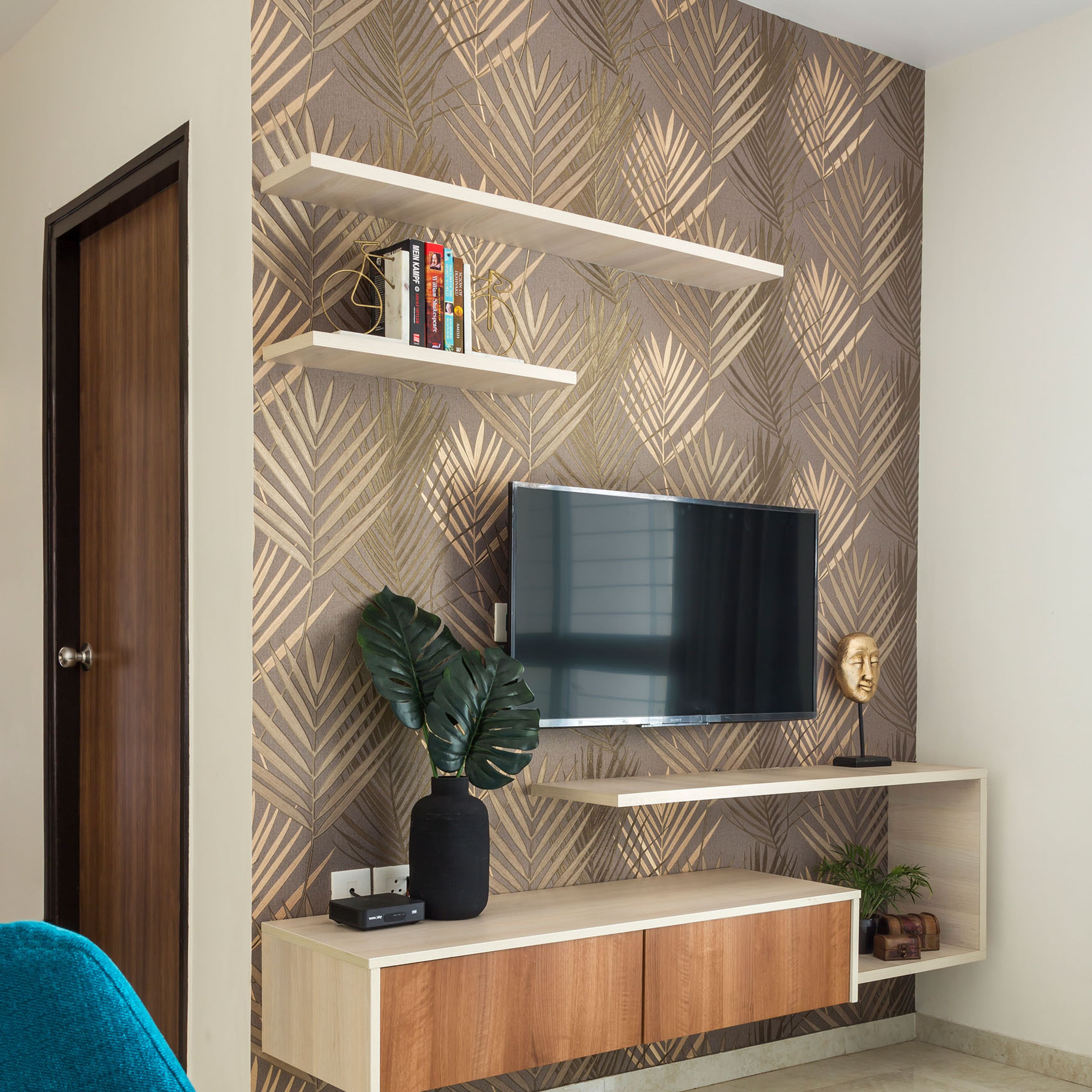 Brown and gold leafy wallpaper for TV unit back panel - Livspace