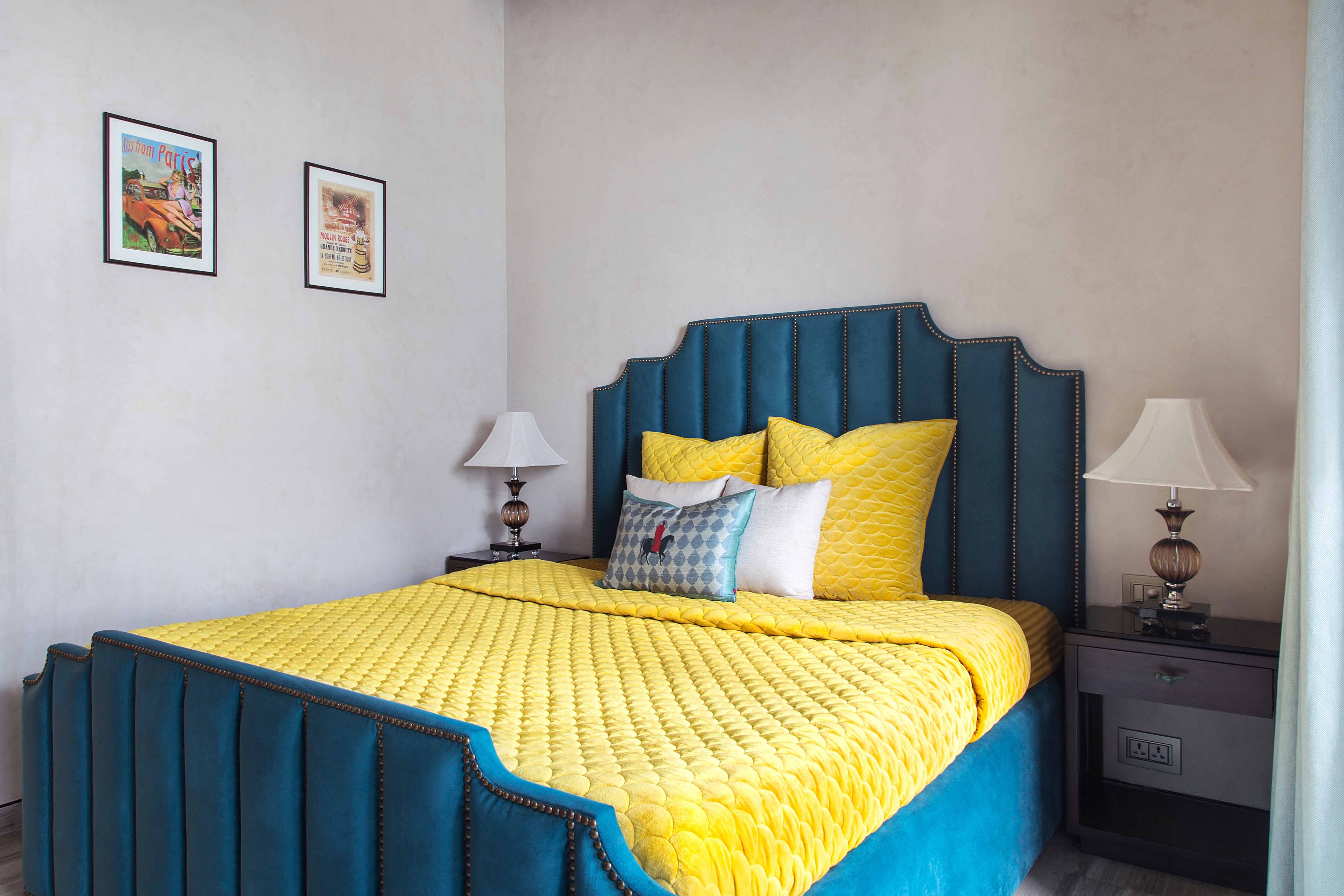 Guest room with teal blue and yellow queen-sized bed - Livspace