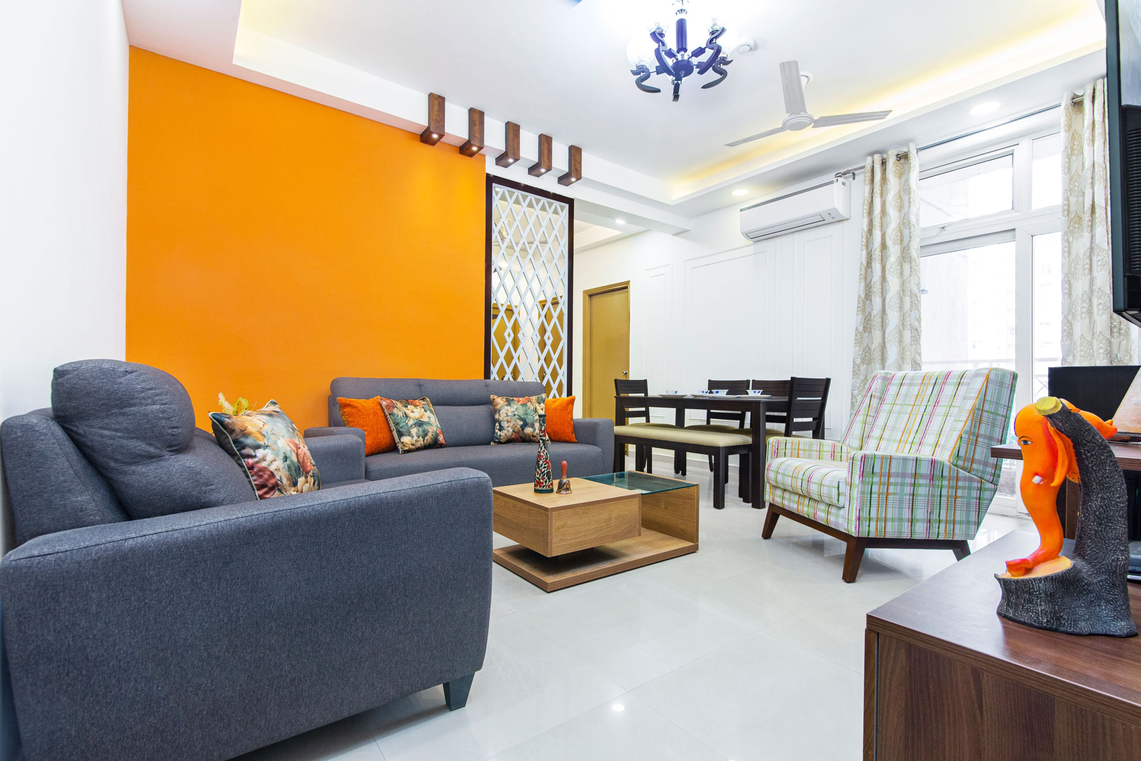 Grey and yellow living room with patterned chair - Livspace