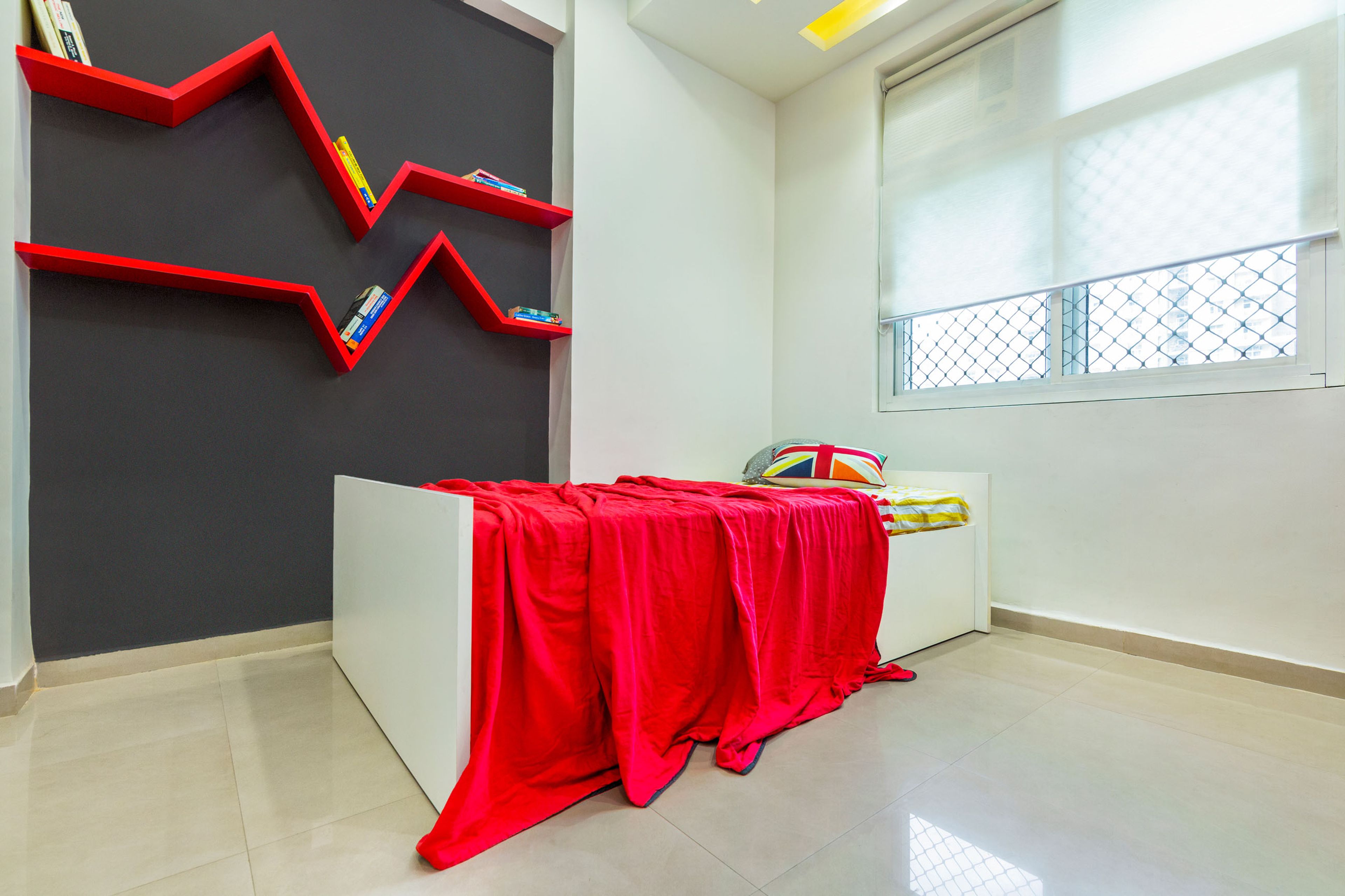 Red and white kids bedroom with storage unit and study unit - Livspace