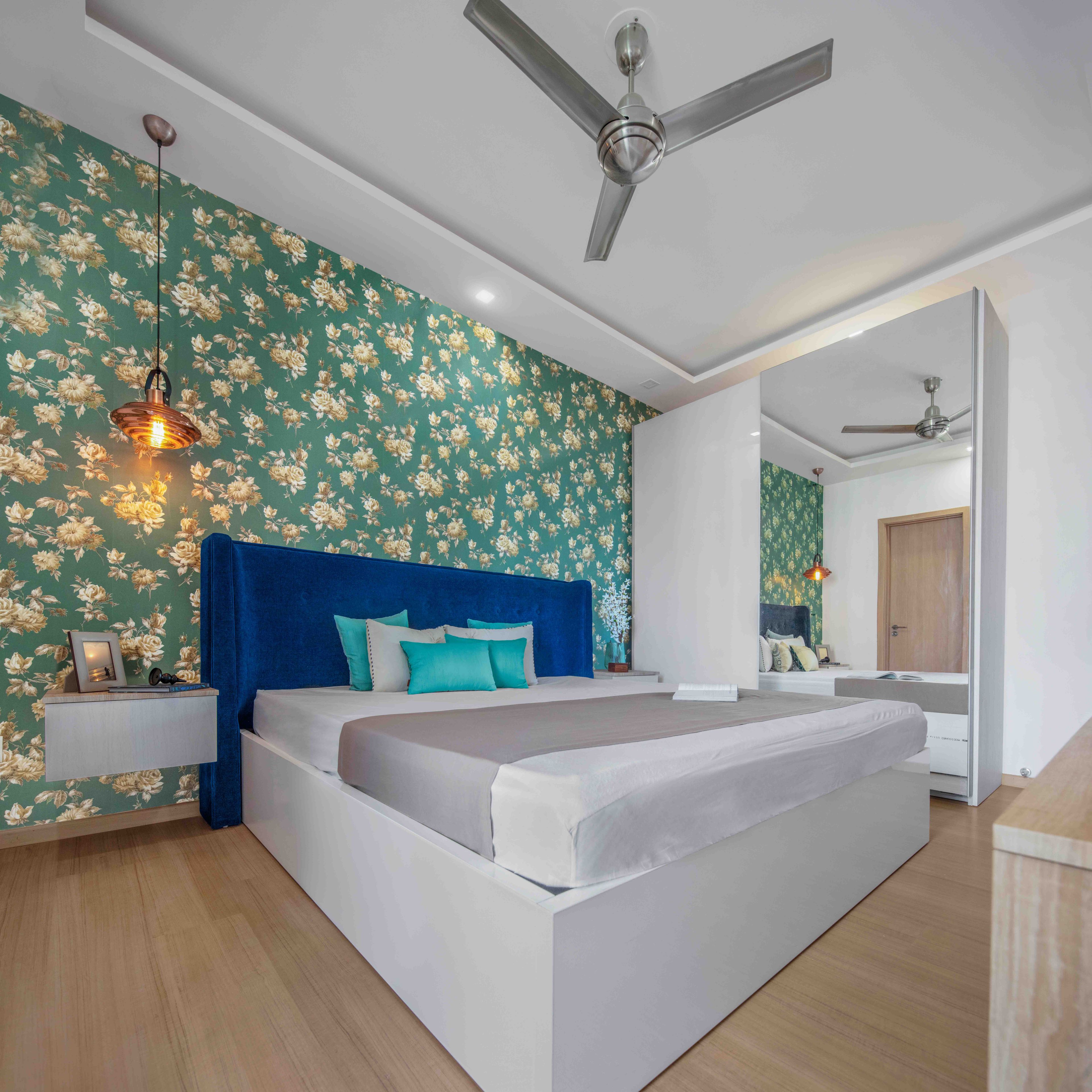 Guest room with green floral wallpaper and sliding wardrobe - Livspace