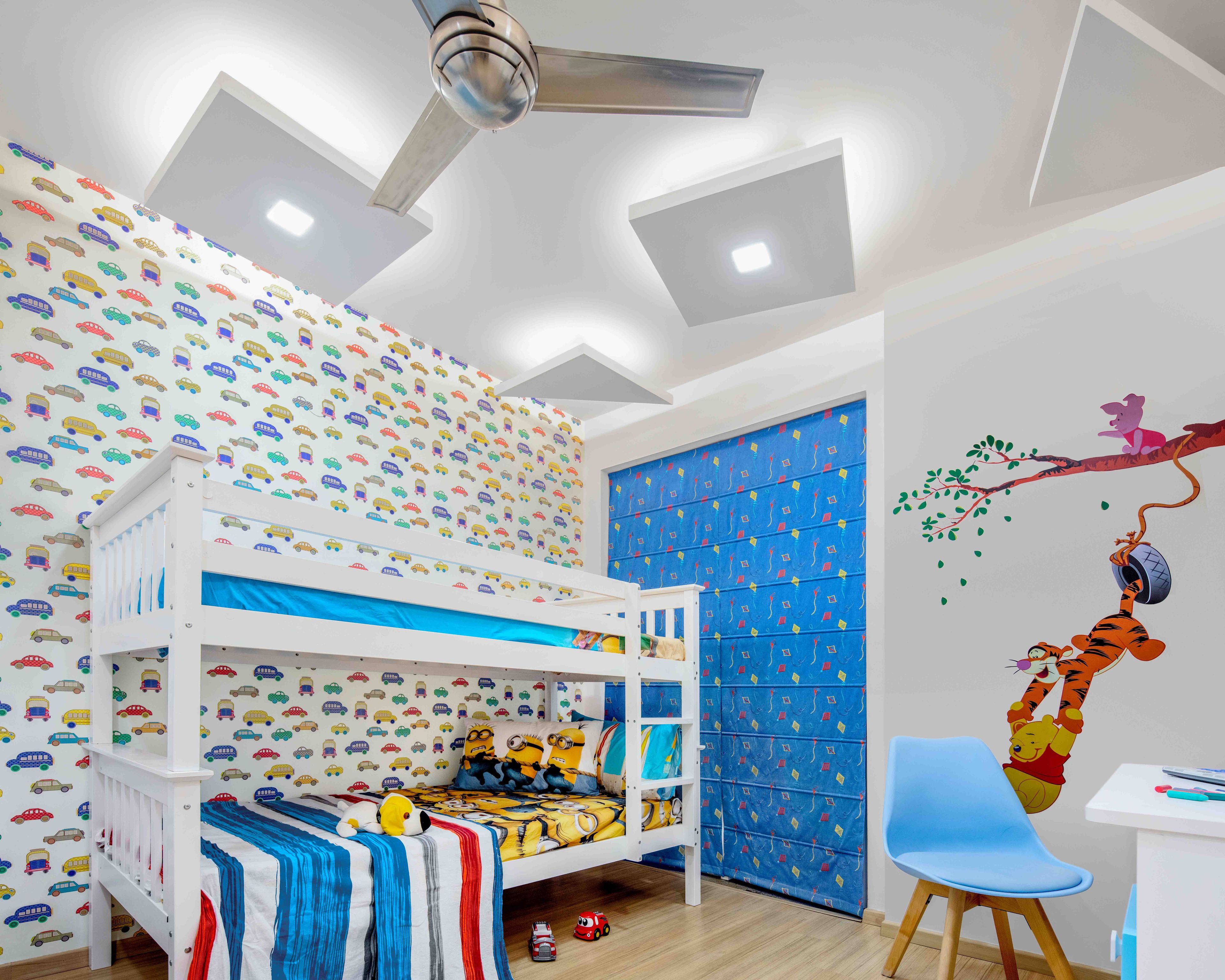 Blue and white kids room with multicoloured wallpaper and open wardrobe with fabric shutter - Livspace