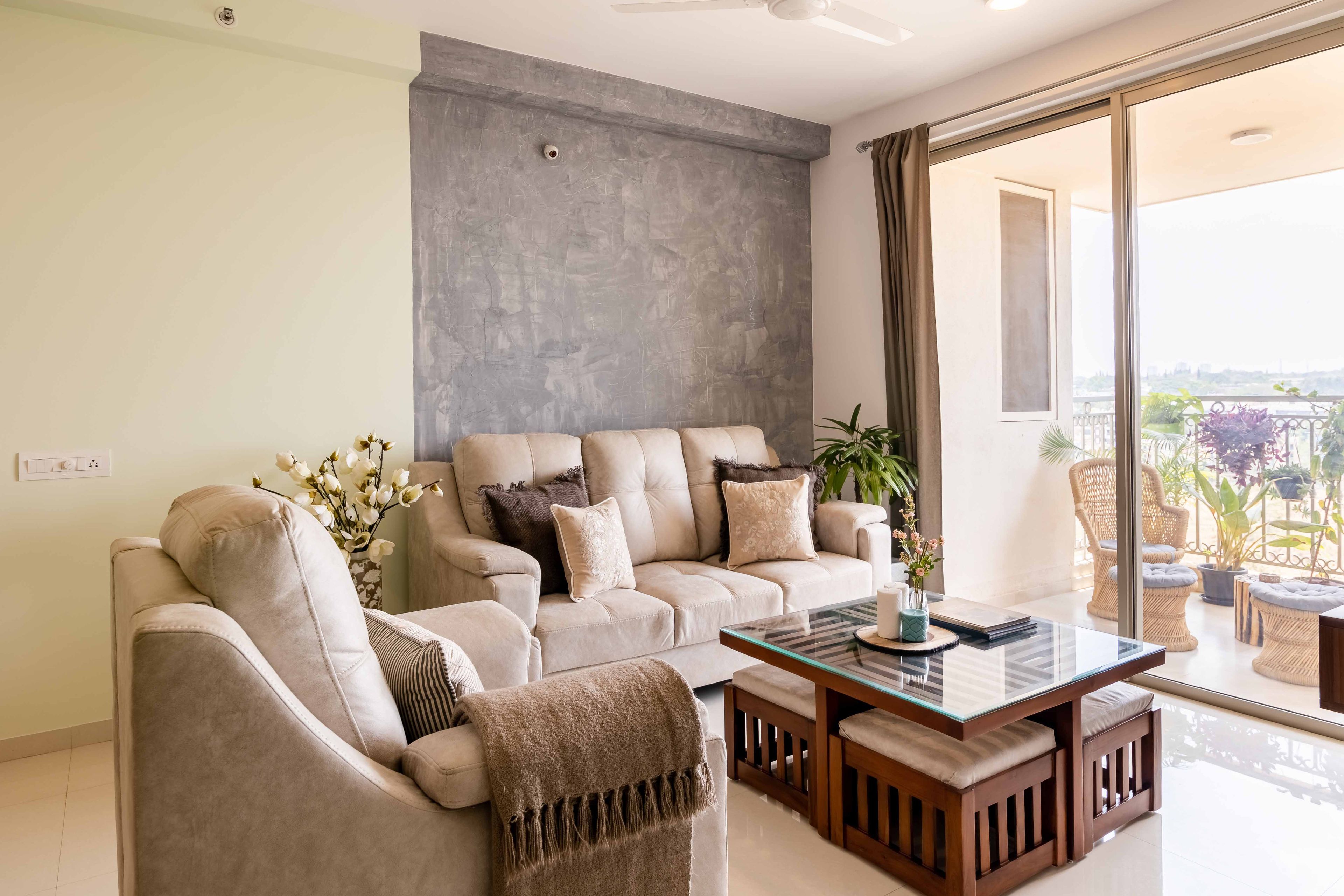 L shaped beige living room with square wooden coffee table -Livspace