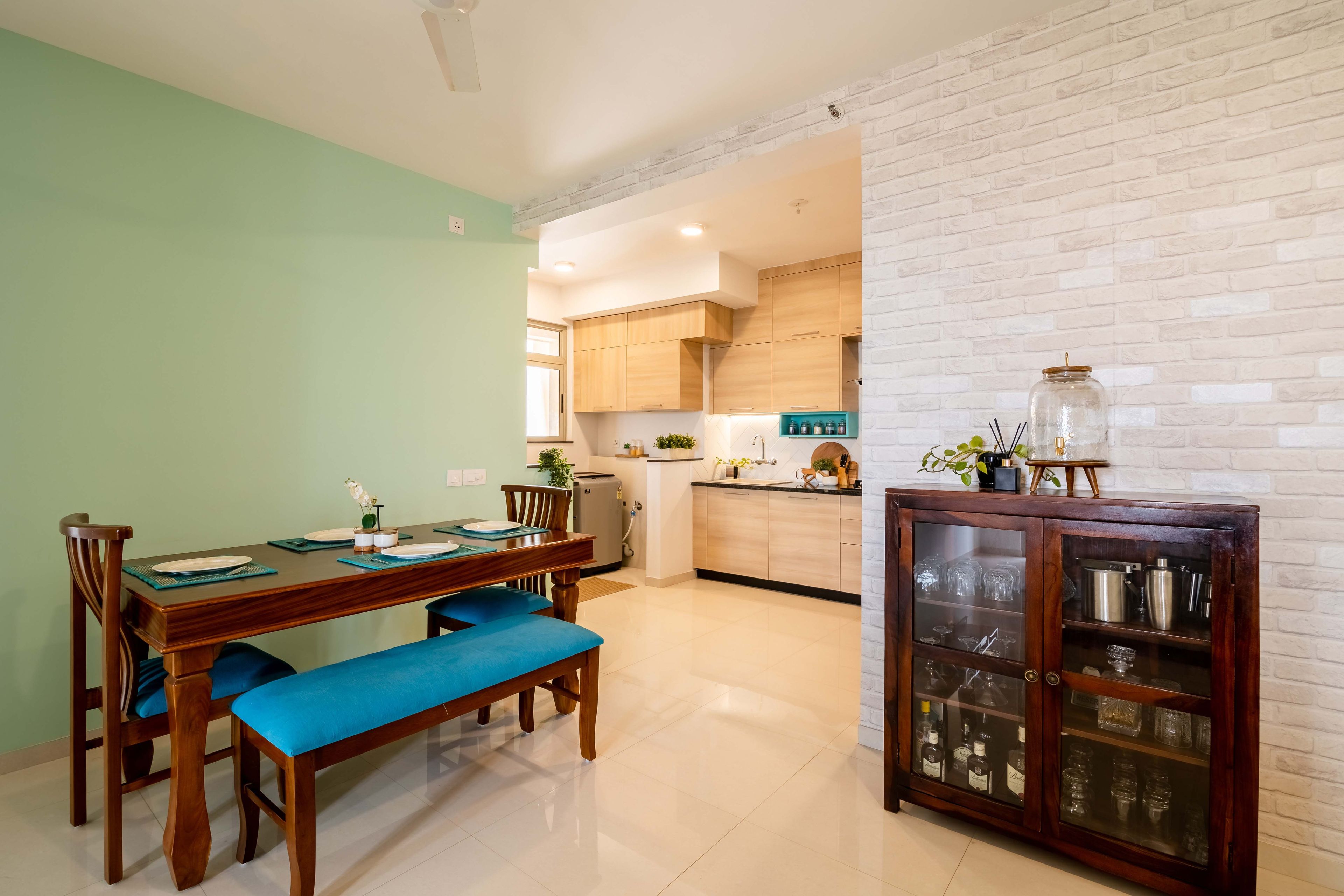 3-seater wood and brown dining table with green accent wall and crockery unit - Livspace