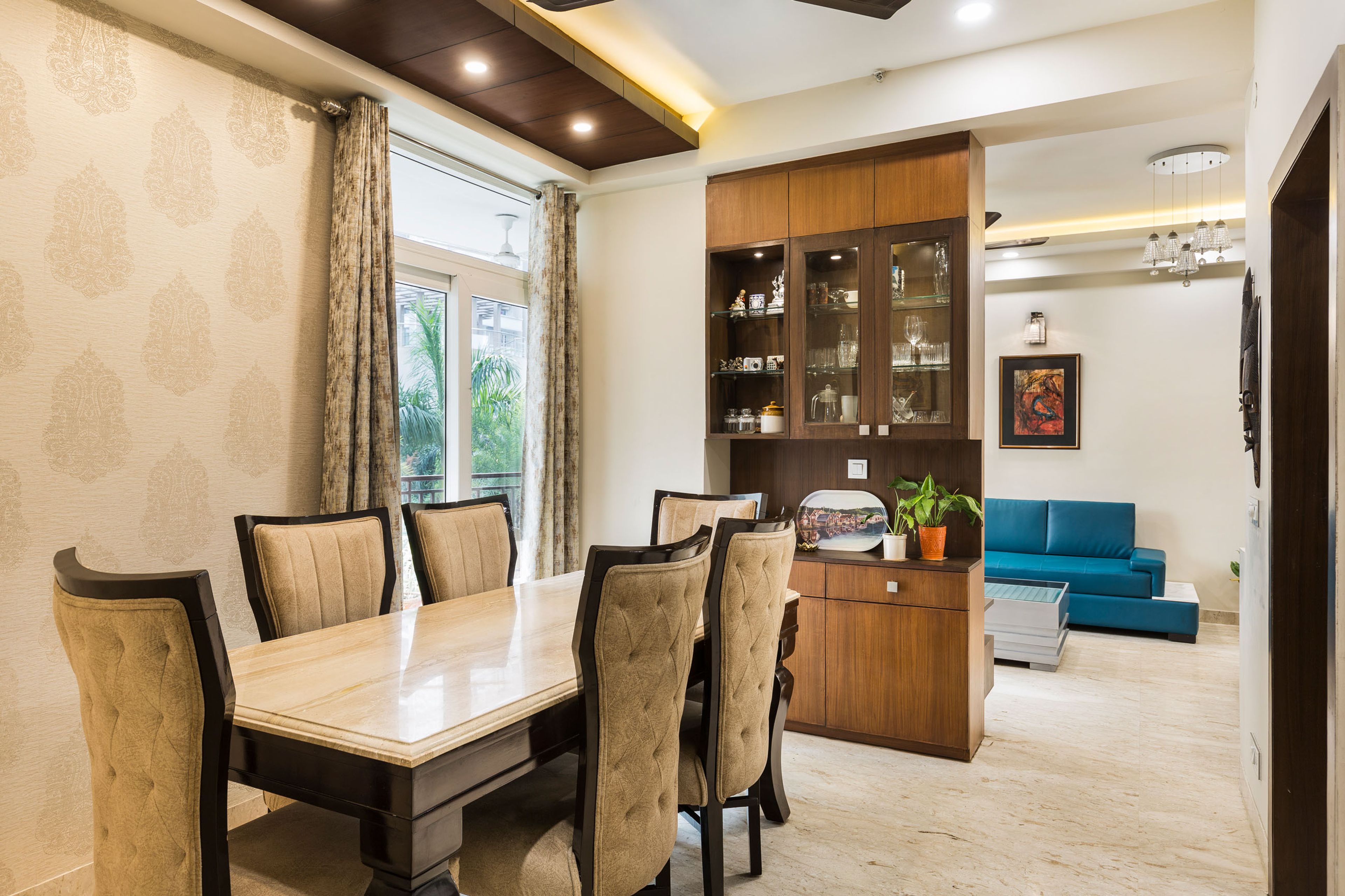 6-seater dining room design with wooden cabinet - Livspace Spacious white master bedroom with granite accent wall- Livspace