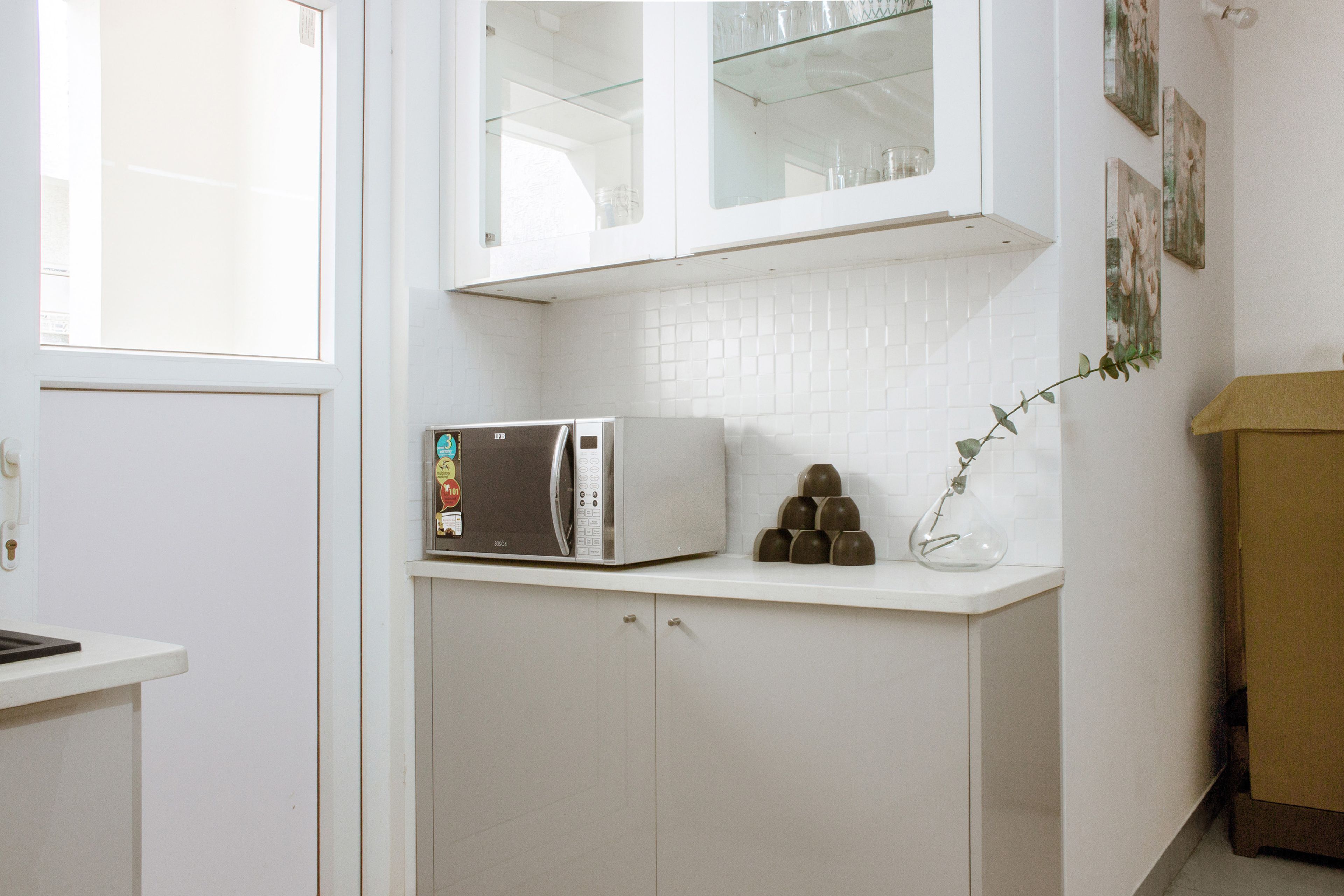 Frosty White L Shaped Modular Kitchen Design With Mosaic Backsplash - Livspace