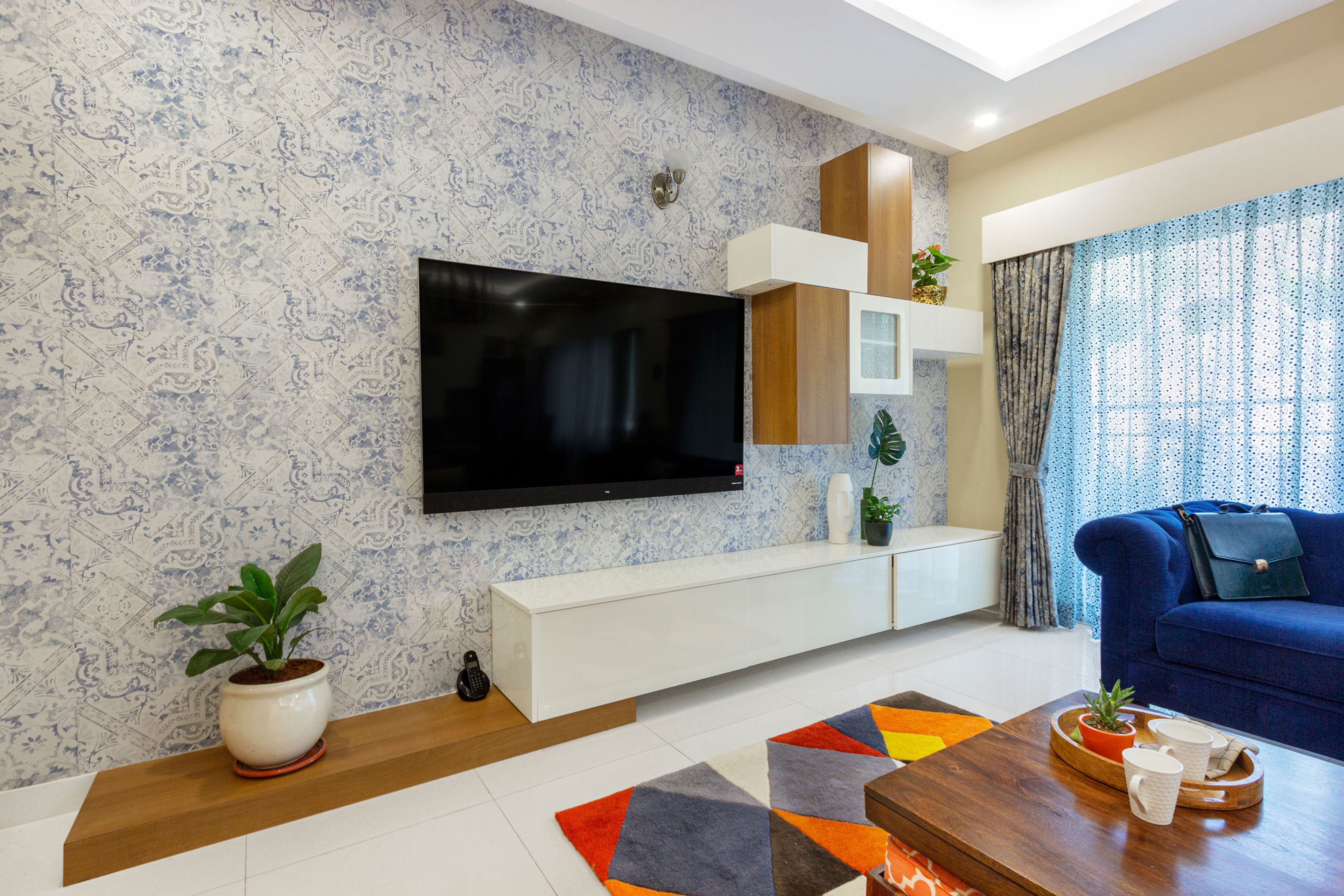 Floor-Mounted White TV Unit Design With Patterned Wallpaper - Livspace