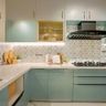 Pastel green and white L-Shaped kitchen with geometric backsplash, wicker basket drawer, and LED lighting