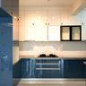 L-Shaped Kitchen Design with Blue Cabinets and Marble Countertops