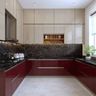 Burgundy and beige kitchen with black marble backsplash and integrated lighting