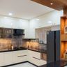 L-Shaped Kitchen Design with Gloss Cabinets and Tall Storage