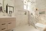 Marble bathroom with walk-in shower, floating vanity, and recessed shelves
