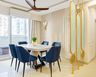 Dining room with blue chairs, white table, golden divider, and natural light