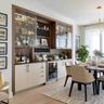 Dining bar with backlit glass cabinets, wine cooler, and wooden cabinetry design