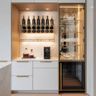 White and gold home bar with glass shelves, LED lighting, and marble accents