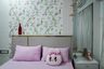 Kids’ bedroom with botanical wall art, pink bedding, soft curtains, and modern side table