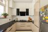 Beige and black U-Shaped marble kitchen with wide drawers and integrated upper cabinetry