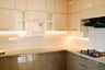 Glossy beige L-shaped kitchen with granite countertop and integrated corner storage