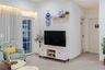White compact TV unit with wooden legs and upper floating shelf in cozy living room